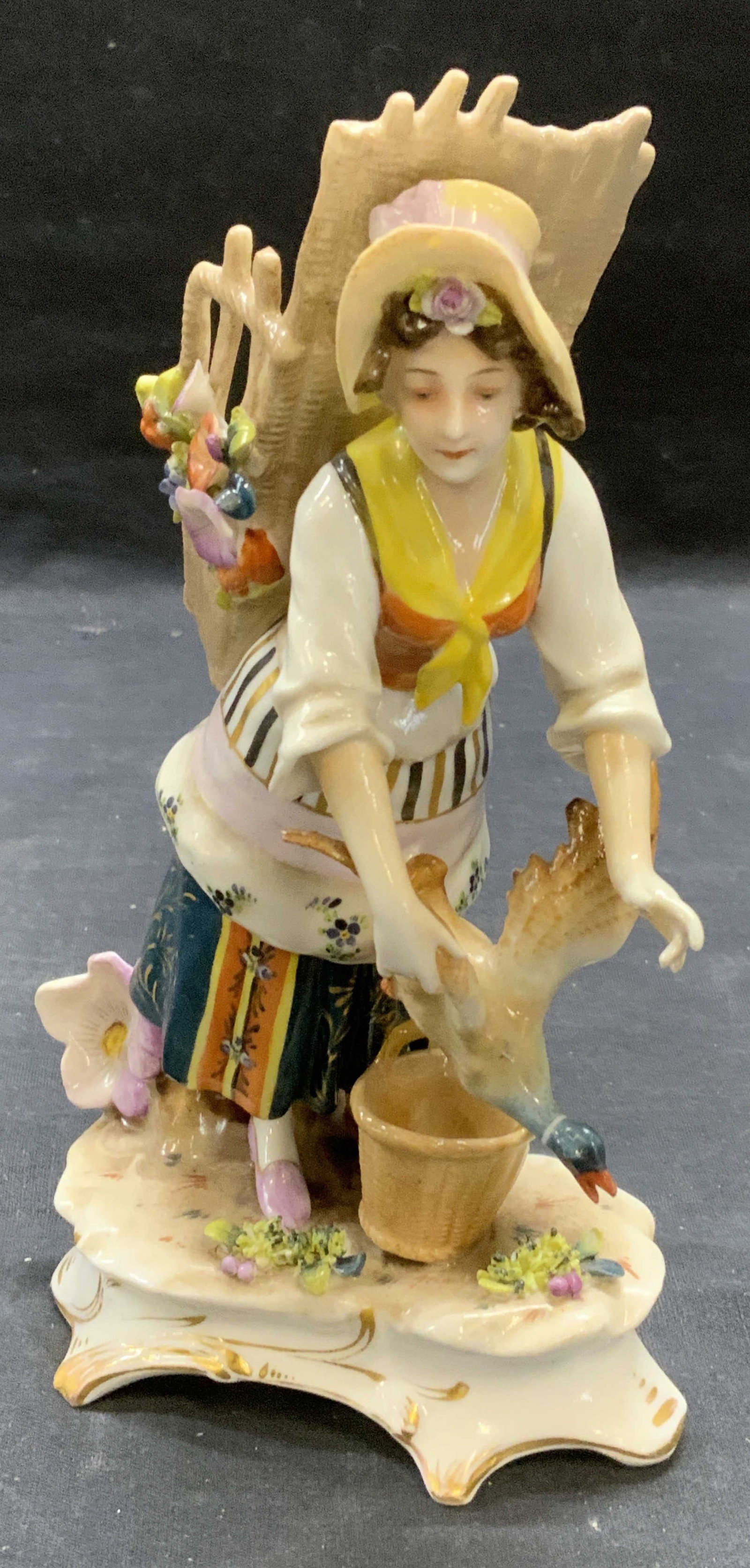 Antique Hallmarked Porcelain Figural: Antique hallmarked porcelain figural. Figural of a woman with basket and duck. Hallmarked illegibly to underside. Marked 877A 21 to underside. Measures approx. 4.25 x 2.5 x 7.25 inches. Some surface w