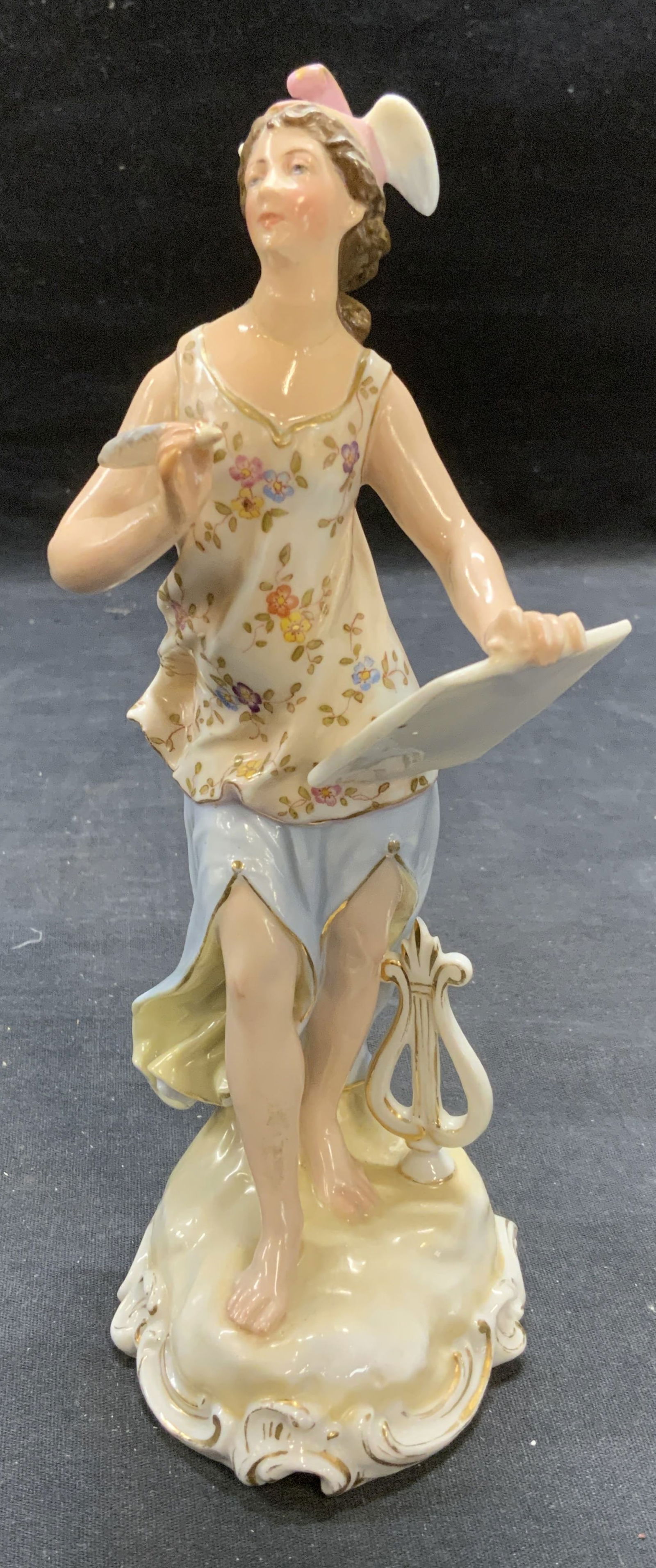 Antique Hallmarked Porcelain Hermes Figurine: Antique hall marked porcelain figurine. Figure of Hermes with tablet and harp. Hallmarked to underside. Measures approx. 3 x 3.5 x 8.25 inches. Some surface wear including scratching observed. Hermes,