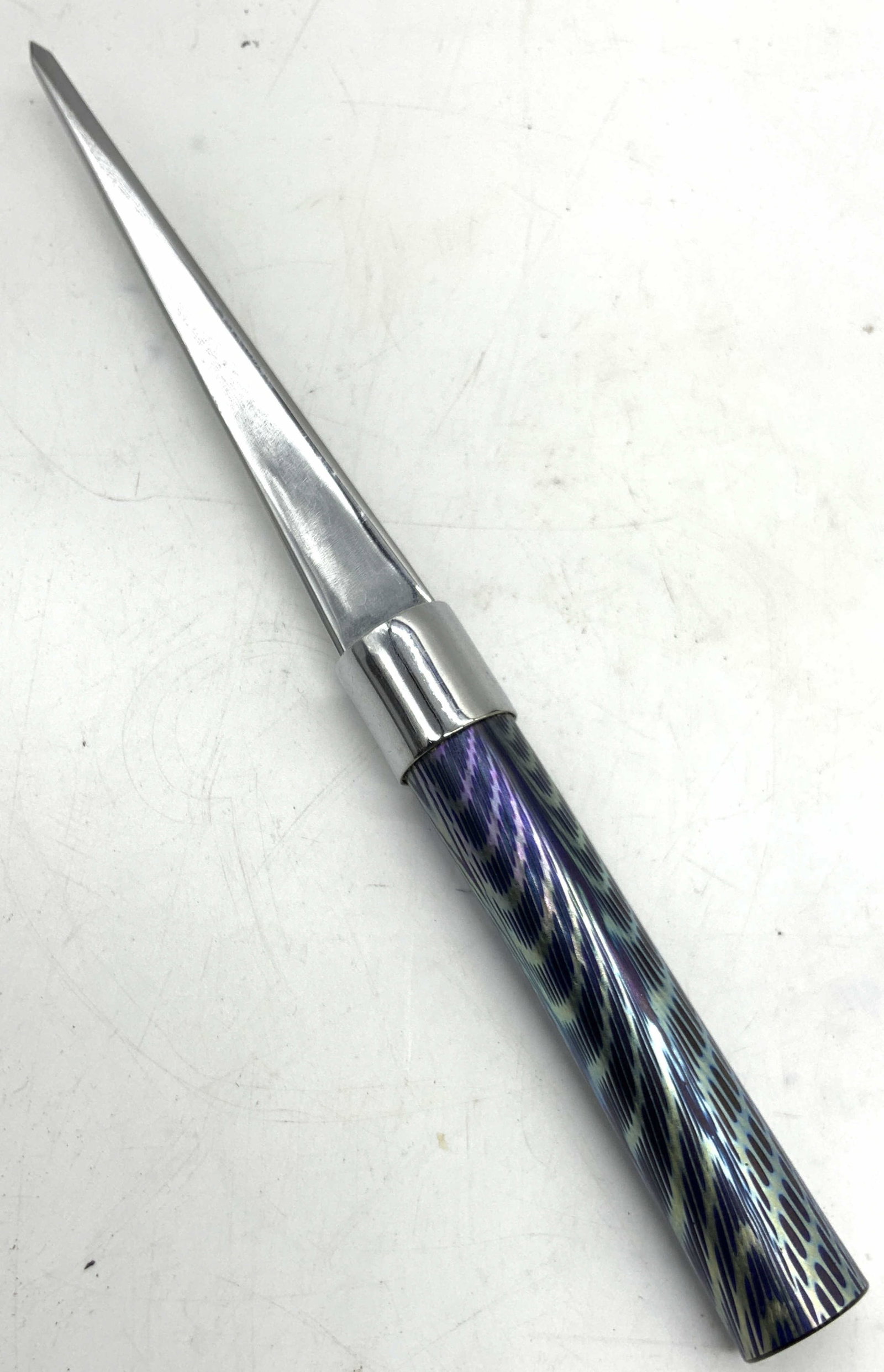 Sgd Art Glass & Steel Letter Opener, 1985: Signed on bottom of handle, illegible name, dates 1980 Steel made letter opener with spiral patterned glass handle in tones of purple and blue Approx 9 inches long. Moderate wearing to steel and minor