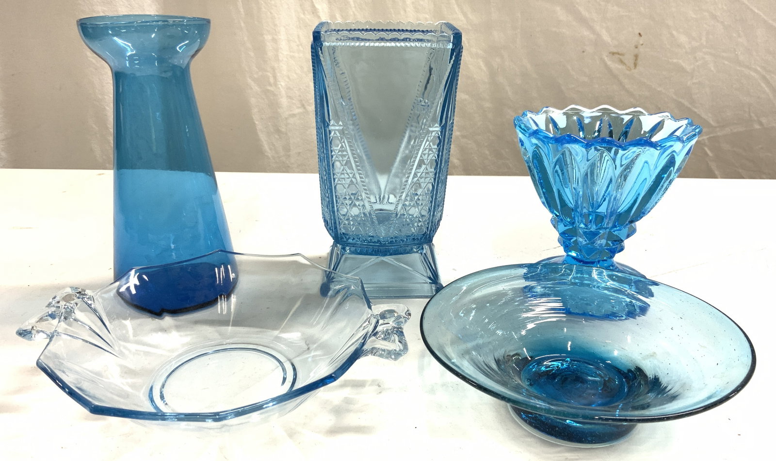 Lot 5 Art Glass Vessels Indian Blue: Lot includes 1 hand blown glass bowl, 1 vase with round toothed vase, 1 dessert cup, 1 bowl with handles, & 1 vase additional vase. Largest vase measures approximately 6.75 inches tall 3.75 inches squ