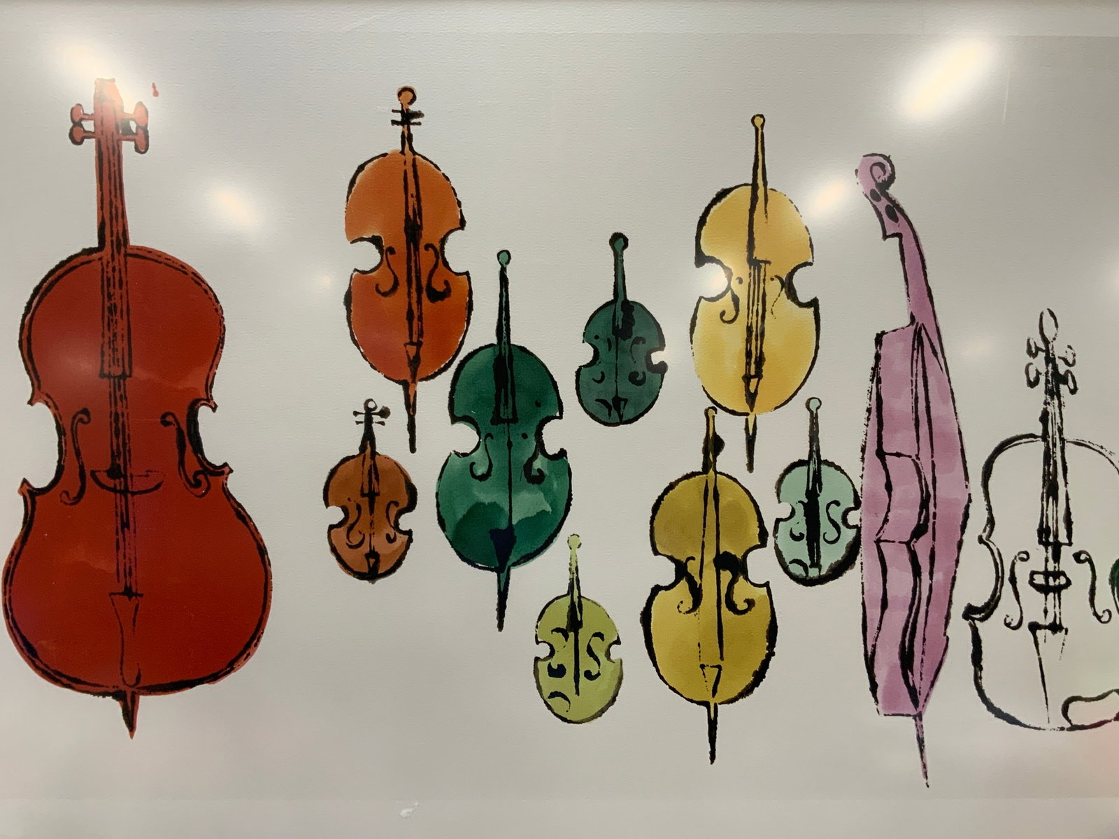 Samantha Goldberg Violins Lithograph 45in: Violin lithograph by Samantha Goldberg. Depicting various colored string instruments against a white background. Framed in a black wooden frame. Approx 31 x 47.5 inches window measures 28 x 45 inches.
