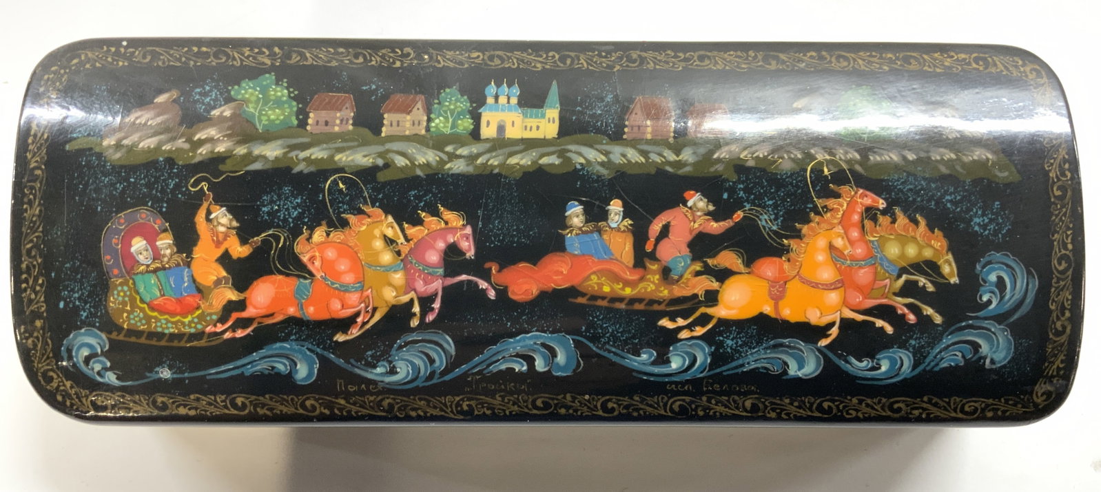 Signed Vntg Lacquered Russian Lidded Trinket Box: Trinket box is signed with Russian characters. Piece is black toned and lacquered with figures riding in horse pulled chariots & architectural & tree detail. Some elements appear to be hand painted. T