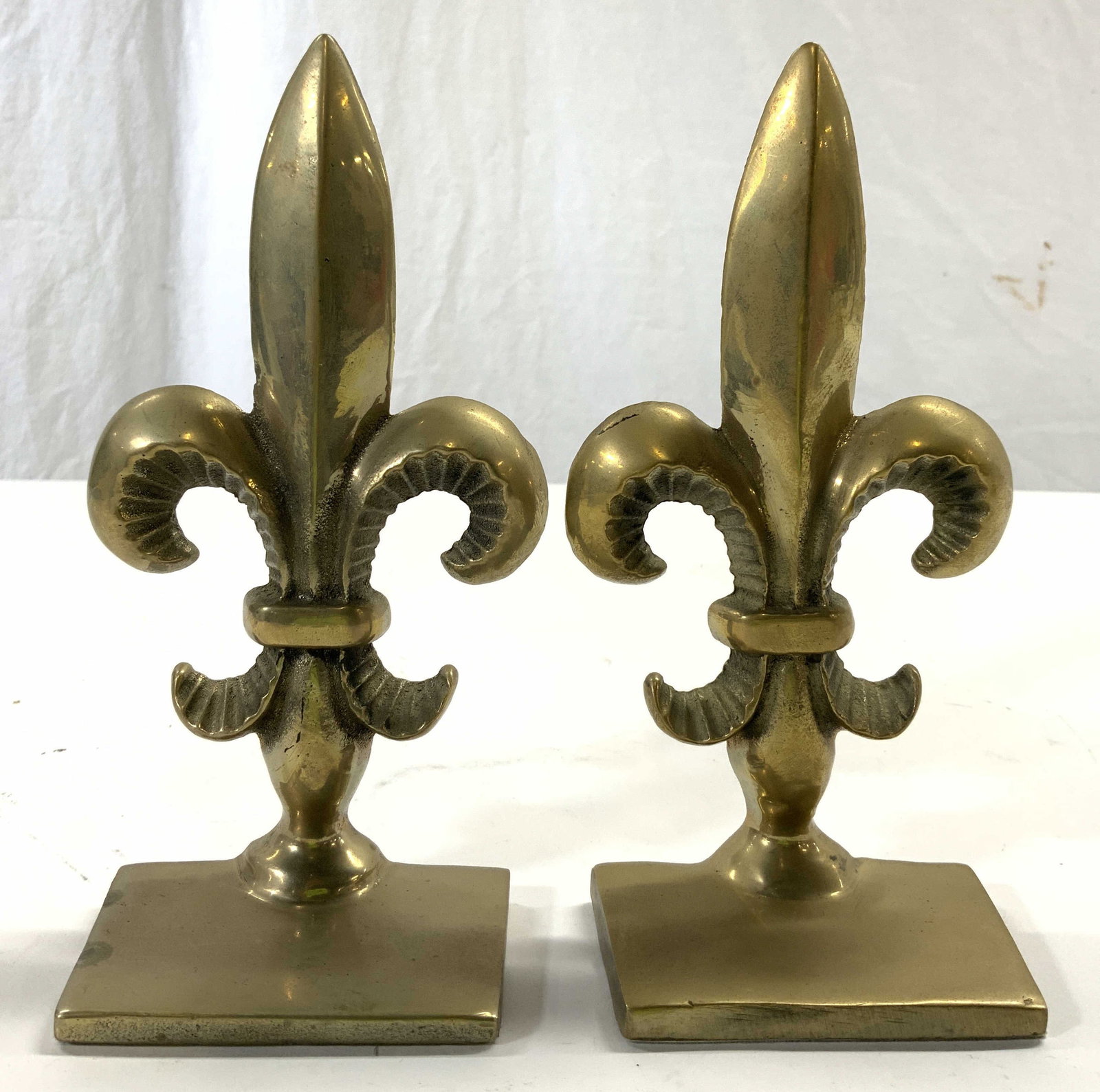ANDREA BY SADEK Brass Fleur De Lis Bookends: Tag on Underside reads ANDREA BY SADEK. Bookends are gold toned & brass. Each have fleur de lis structure. Bookends each measure approximately 6.75 inches tall 3.5 inches wide 1.75 inches deep. Andrea