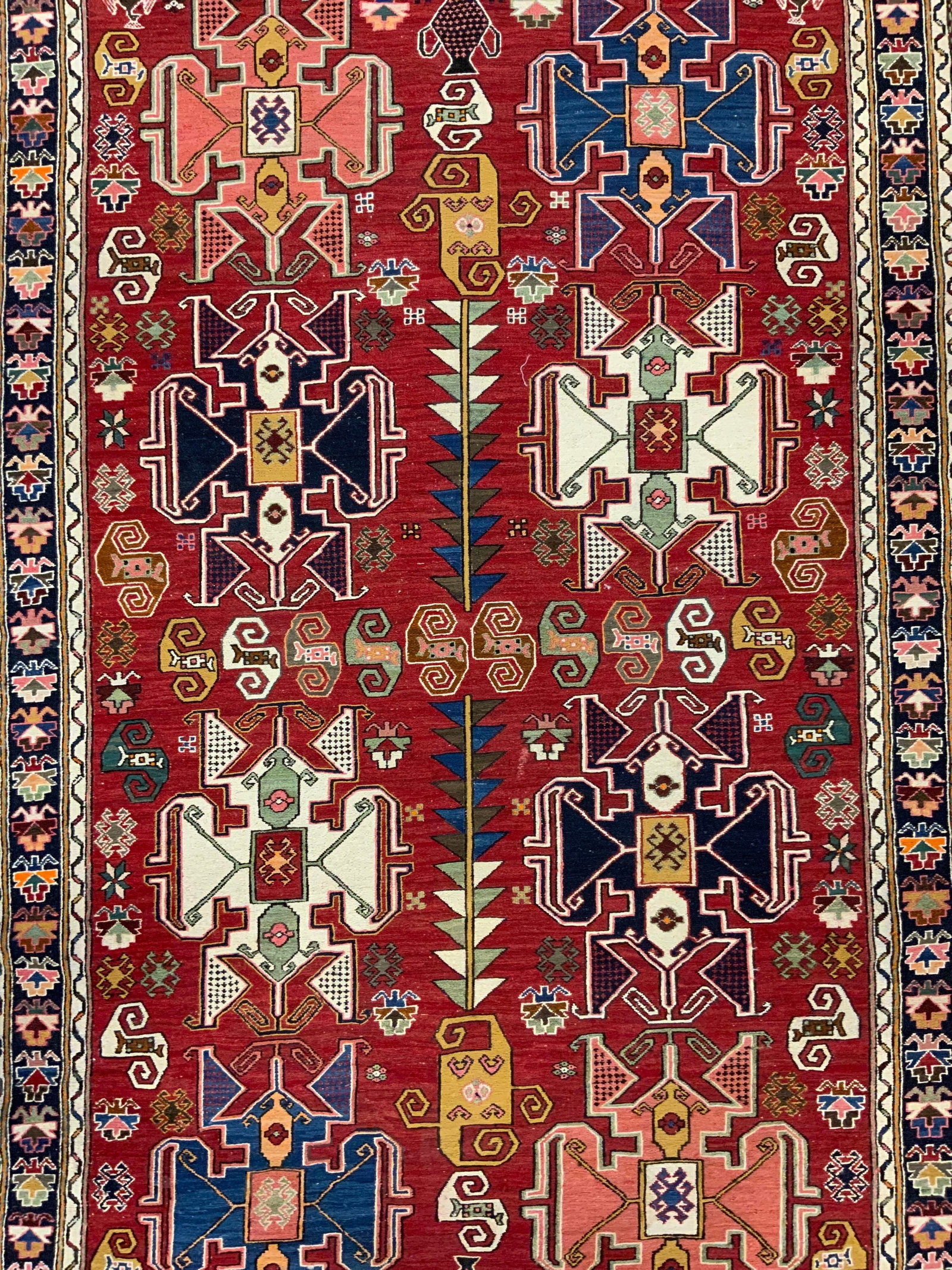 Vintage Handmade Fringed Wool Area Rug: Rug is handmade and wool. Piece has cream toned fringes at edges of one side. Rug has intricate multi toned geometric detail. Rug appears to be Persian. Piece measures approximately 85 inches long 49 