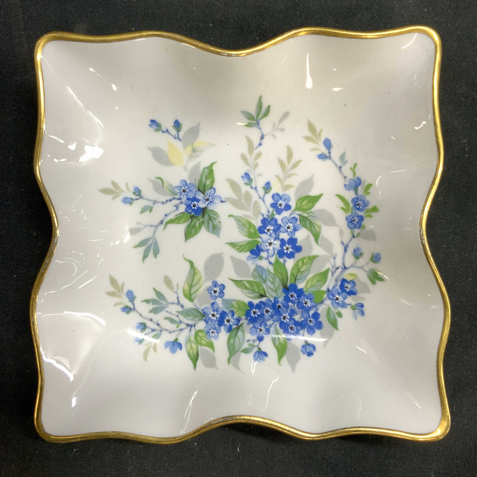 LIMOGES FRANCE Vtg Gilt Rim Floral Porc Trink Dish: Underside is marked LIMOGES FRANCE. Piece is cream toned and porcelain with multi toned floral and leaf detail. Piece has gilt rim. Trinket dish measures approximately 5.75 inches wide and deep. Limog