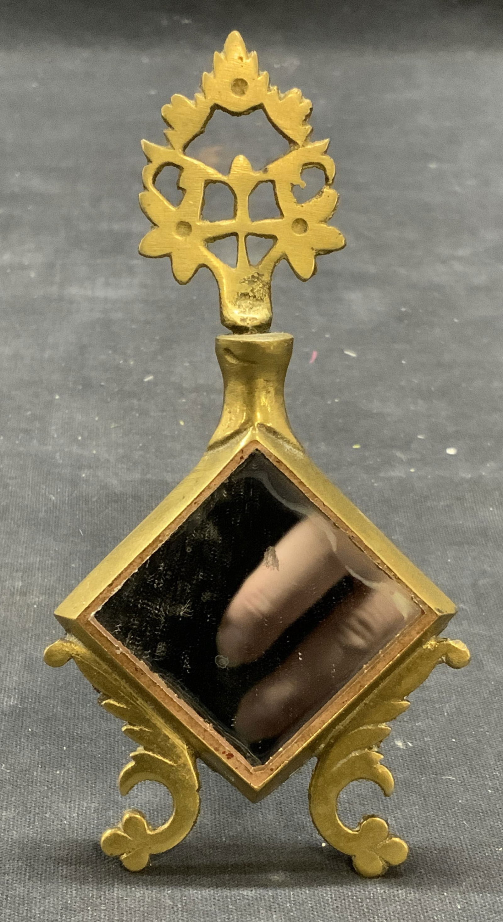 Vintage Brass Footed Mirror: Vintage brass footed mirror with pierced detail and scroll feet. Easel back. Measures approx. 4.75 x 2.5 inches. Some surface wear including scratching observed. Mirror, vintage mirror, brass mirror,