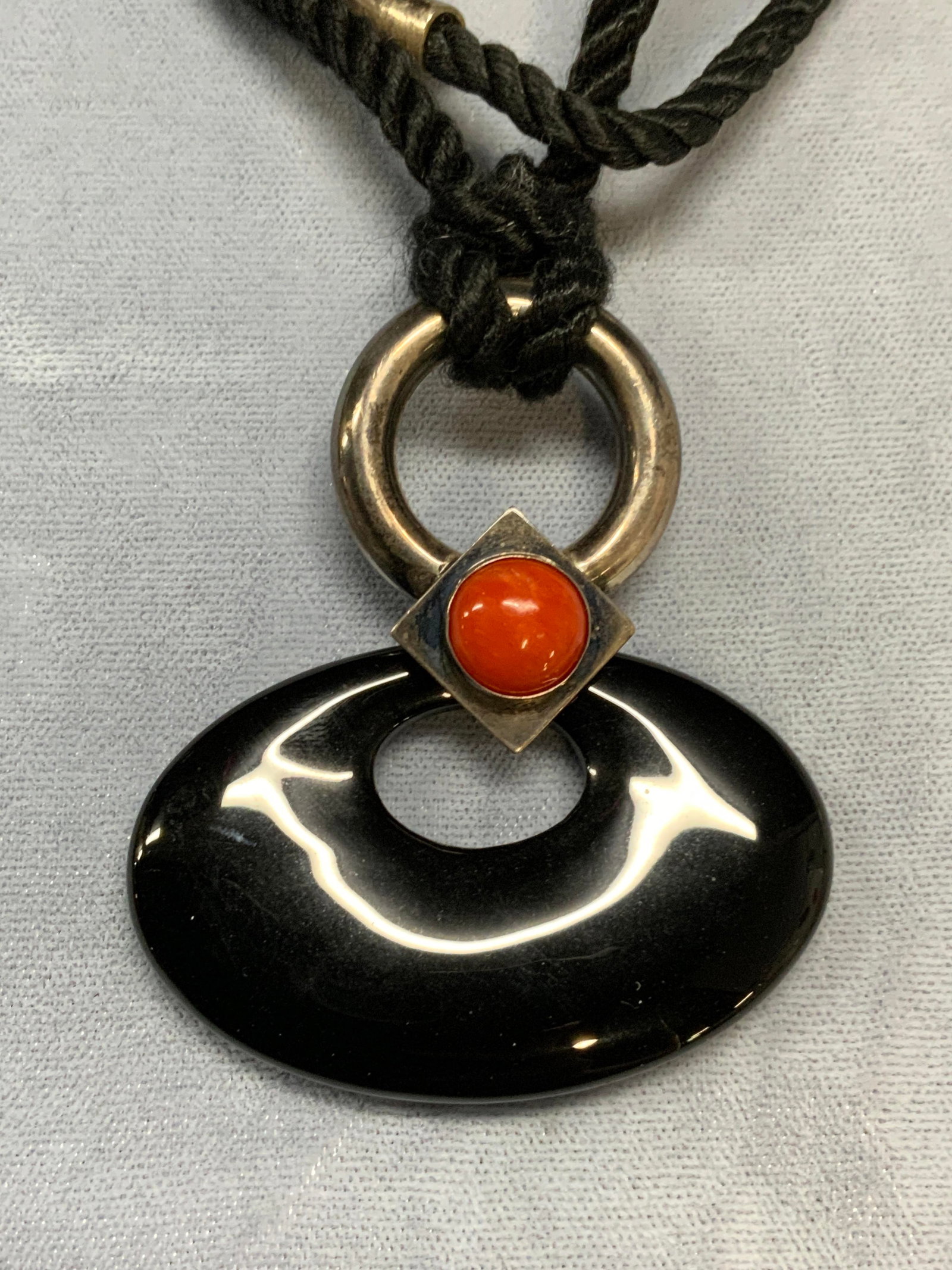 Black Stone & Sterling Slvr Pendant Necklace: Black stone and red glass cabochon pendant necklace on black cord. Hand crafted sterling silver accent, marked on silver. Drop length approx. 13.5 inches. Some surface wear including scratching observ