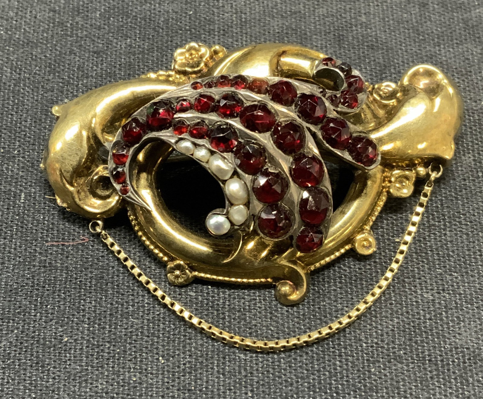 Vintage Gold Filled Garnet & Pearl Brooch: Vintage gold filled brooch with garnet gemstone and seed pearl decoration. Hinge pin to underside. Measures approx. 1.25 x 2 inches. Some surface wear including scratching observed. Estate jewelry, co
