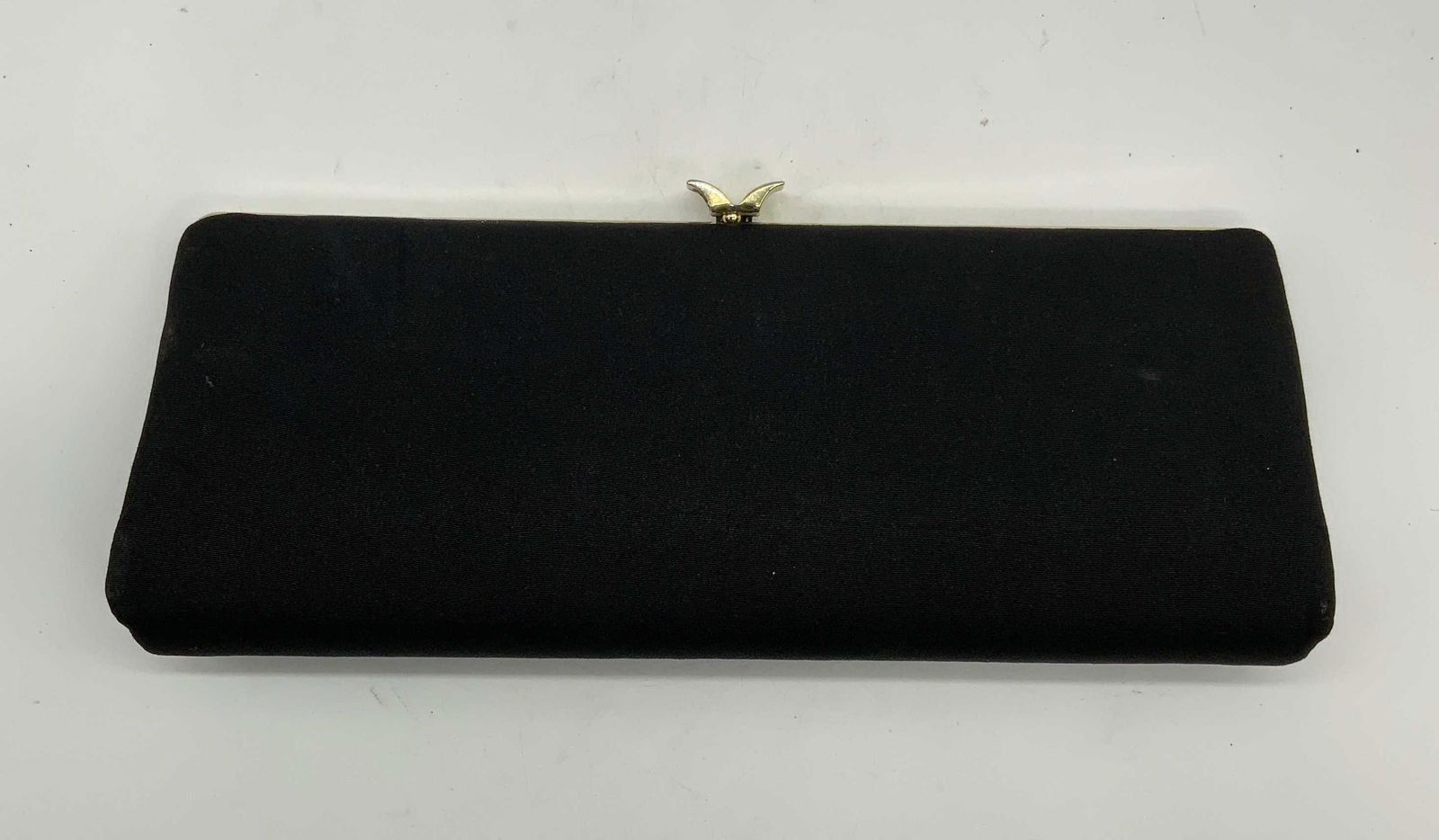 Gold Tone Black Fabric Clutch: Black fabric clutch with gold tone frame and push clasp. 1 slip pocket to interior. Measures approx. 11.5 x 1.75 x 4.25 inches. Some wear to material including blemishes observed. Ladies clutch, ladie