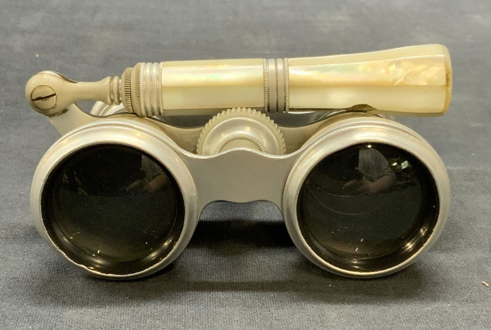 Vintage Tris Paris Mother of Pearl Opera Glasses: Vintage Tris Paris silver tone mother of pearl opera glasses. Trademarked on lens frame. Measures approx. 4.25 inches wide and 2.5 inches long. Handle measures approx. 4.5 inches long. Surface wear in