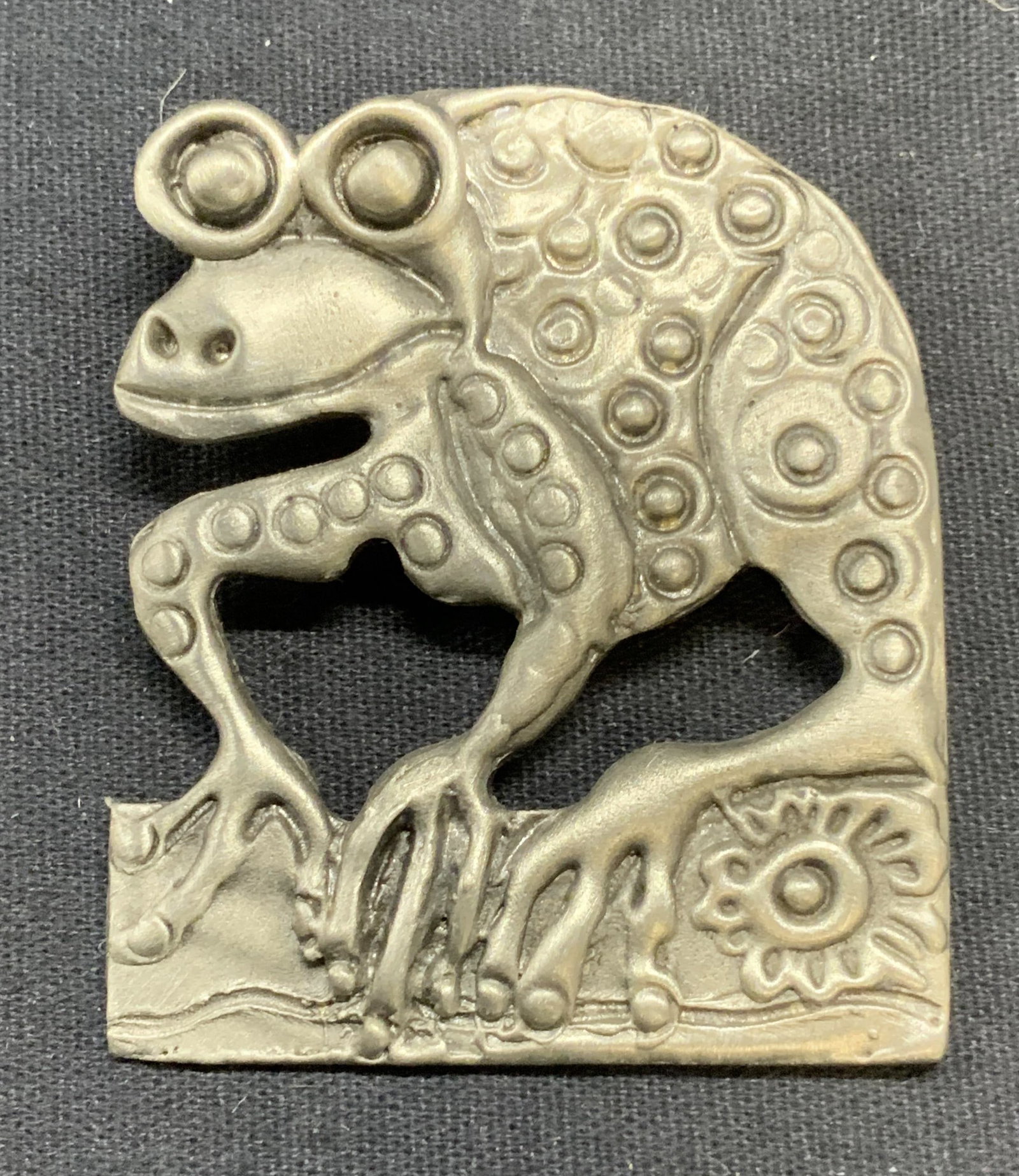 Drumm Silver Tone Frog Brooch: Drumm silver tone frog brooch. Embossed raised surface. Signed to underside. Hinge pin to underside. Measures approx. 2 x 1.75 inches. Some surface wear including scratching observed. Estate jewelry, 