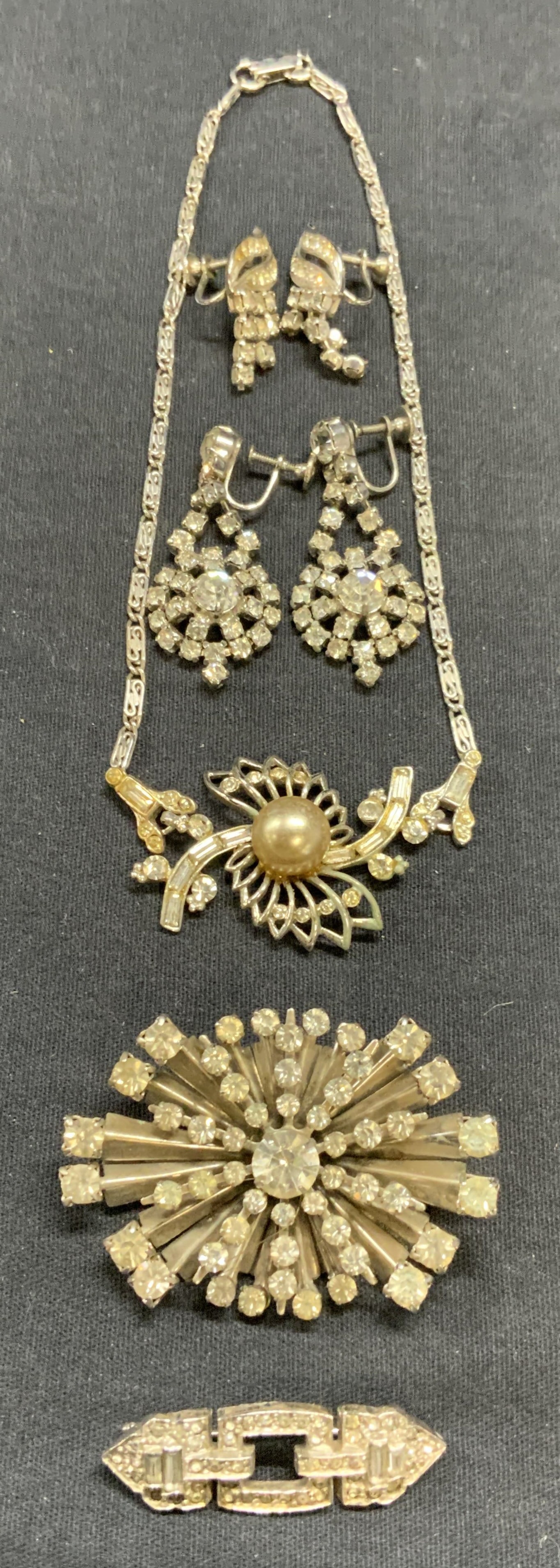Lot 5 Vintage Silver Tone Crystal Jewelry: Lot of 5 vintage silver tone and colorless crystal decorated jewelry pieces. Includes necklace, two pairs of earrings, and two brooches. Necklace drop length approx. 5.75 inches. Largest brooch measur
