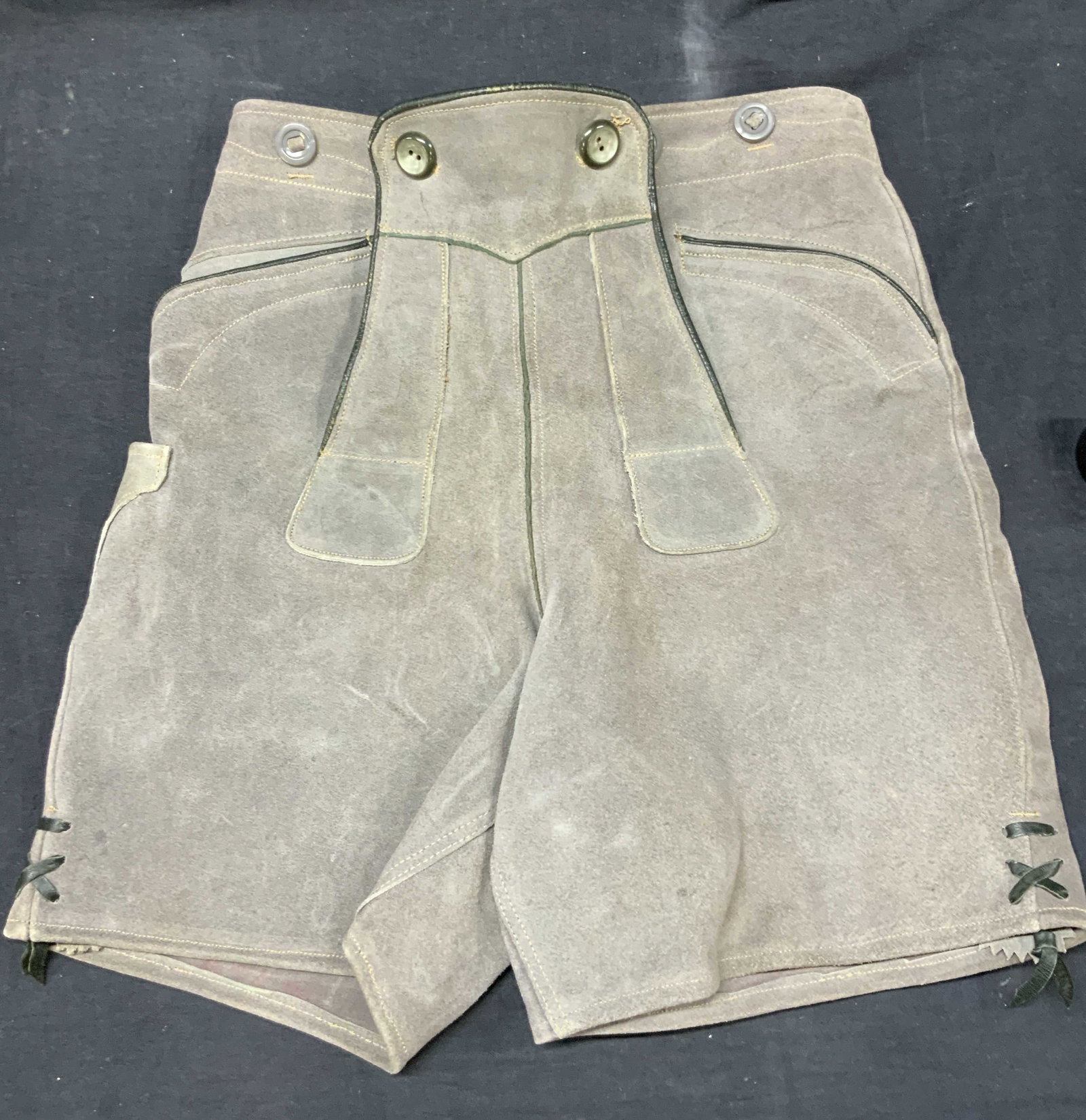 Vtg Leather Made Lederhosen Shorts: Pair of gray toned leather crafted lederhosen shorts, stamped by makers on interior. Inseam is approx 5 inches long, outer seam from waist to short end is approx 16 inches long and waist measures 11 i