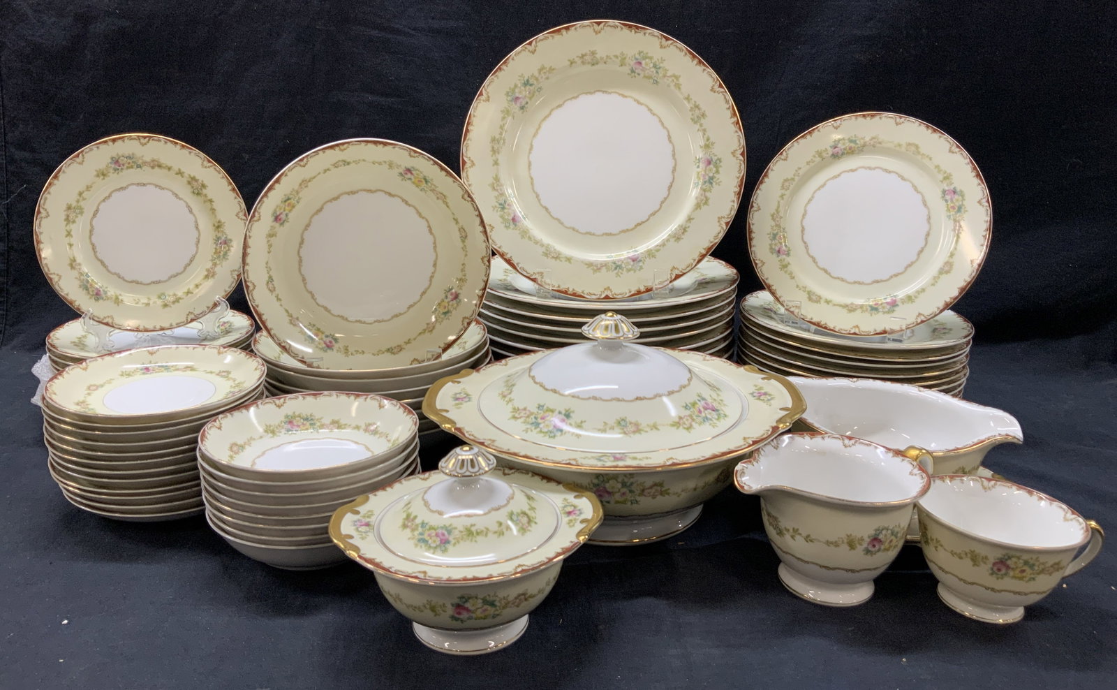 Set 68 Dubarry Floral Porcelain Dishes, Japan: Set of 68 Dubarry marked dishes with gilt rims and handles and floral bouquet motifs on edges and centers of dishes. 1 lidded serving dish at 10 inch diameter. 1 lidded sugar bowl 1 pitcher and 1 grav