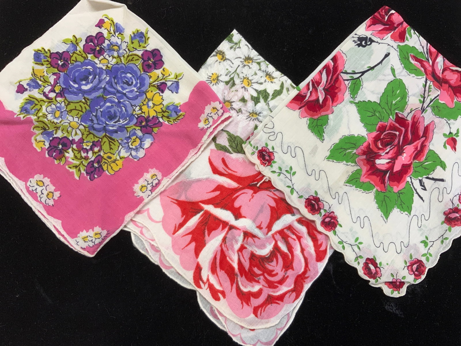 Lot 3 Vtg Floral Cotton Hankies: Vintage cotton hankies. Purple rose hankie with pink border and hand rolled edges measures 11.75 x 12 in. Daisy posey with red roses, measures 13 x 13 in. Red roses with red rose border, measures 12 x