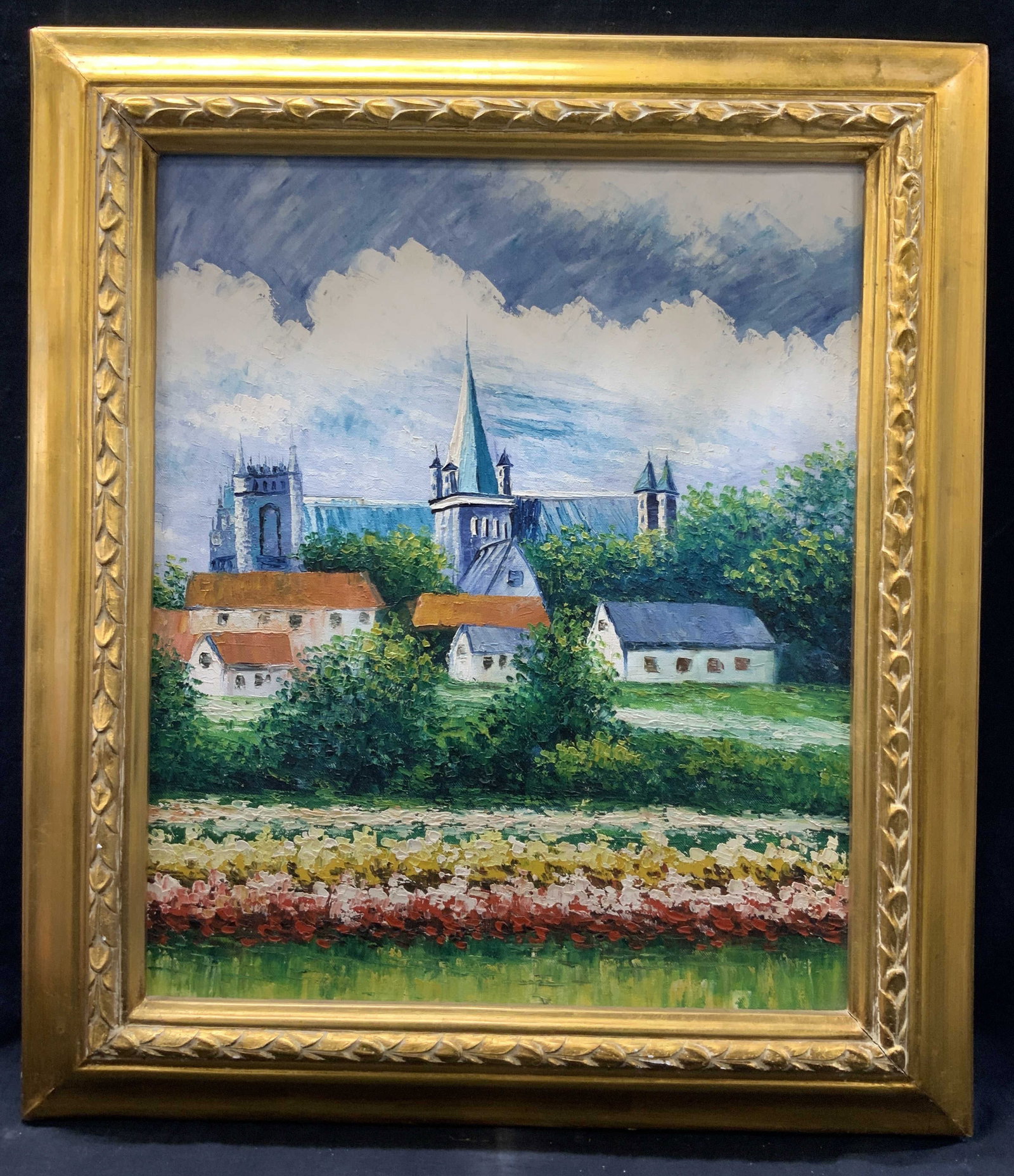Litchfield Cathedral Landscape Oil Painting: Landscape oil painting on canvas depicting the Litchfield cathedral behind houses against a forest. Framed in a floral carved gold leafed wooden framed approx 29 x 26 inches window measures 23 x 18 in
