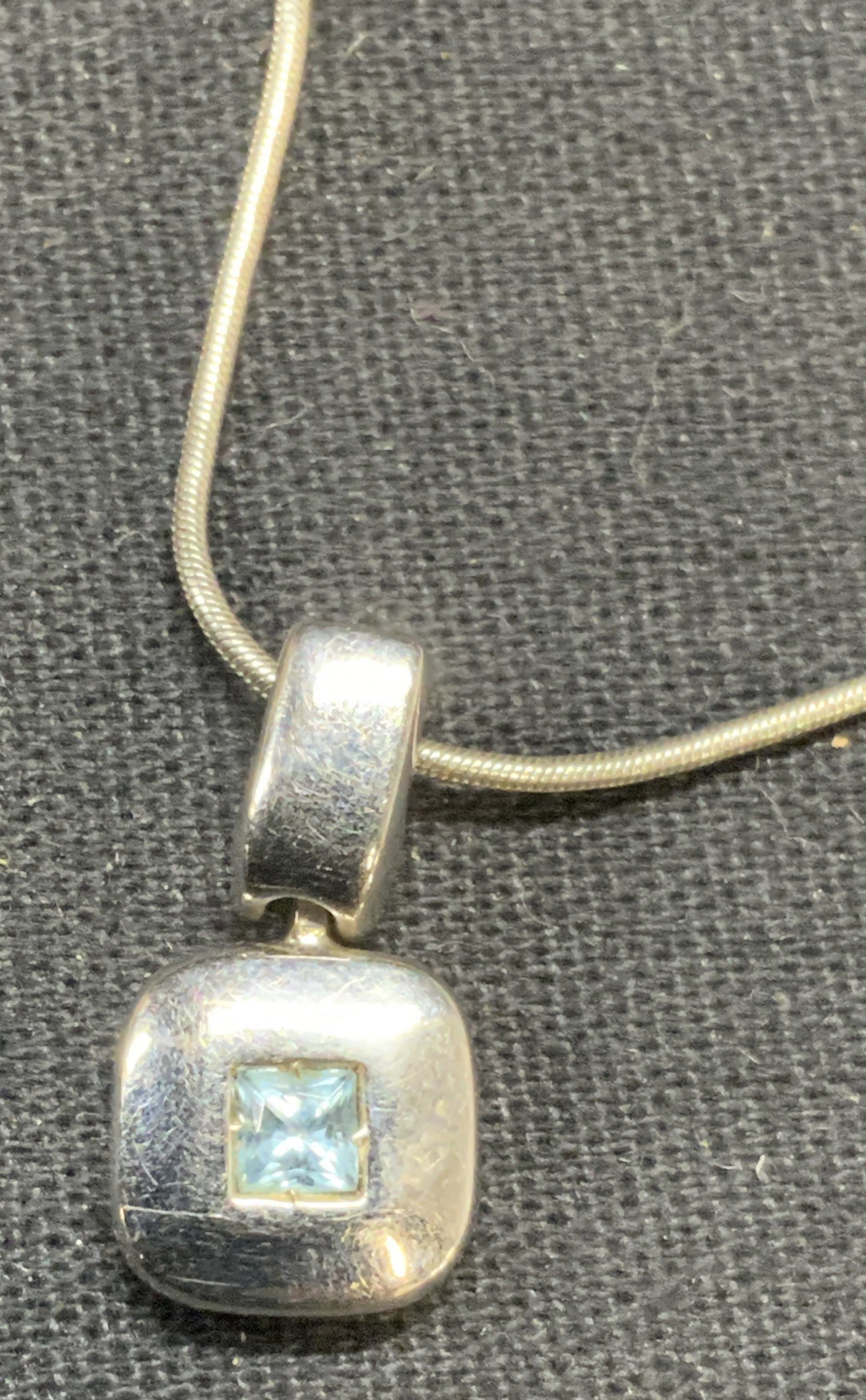 Silver Tone Gemstone Pendant Necklace: Silver tone pendant necklace with blue and green gemstones. Hallmarked illegibly on hang tag. Drop length approx. 7.5 inches. Some surface wear including scratching observed. Estate jewelry, costume j