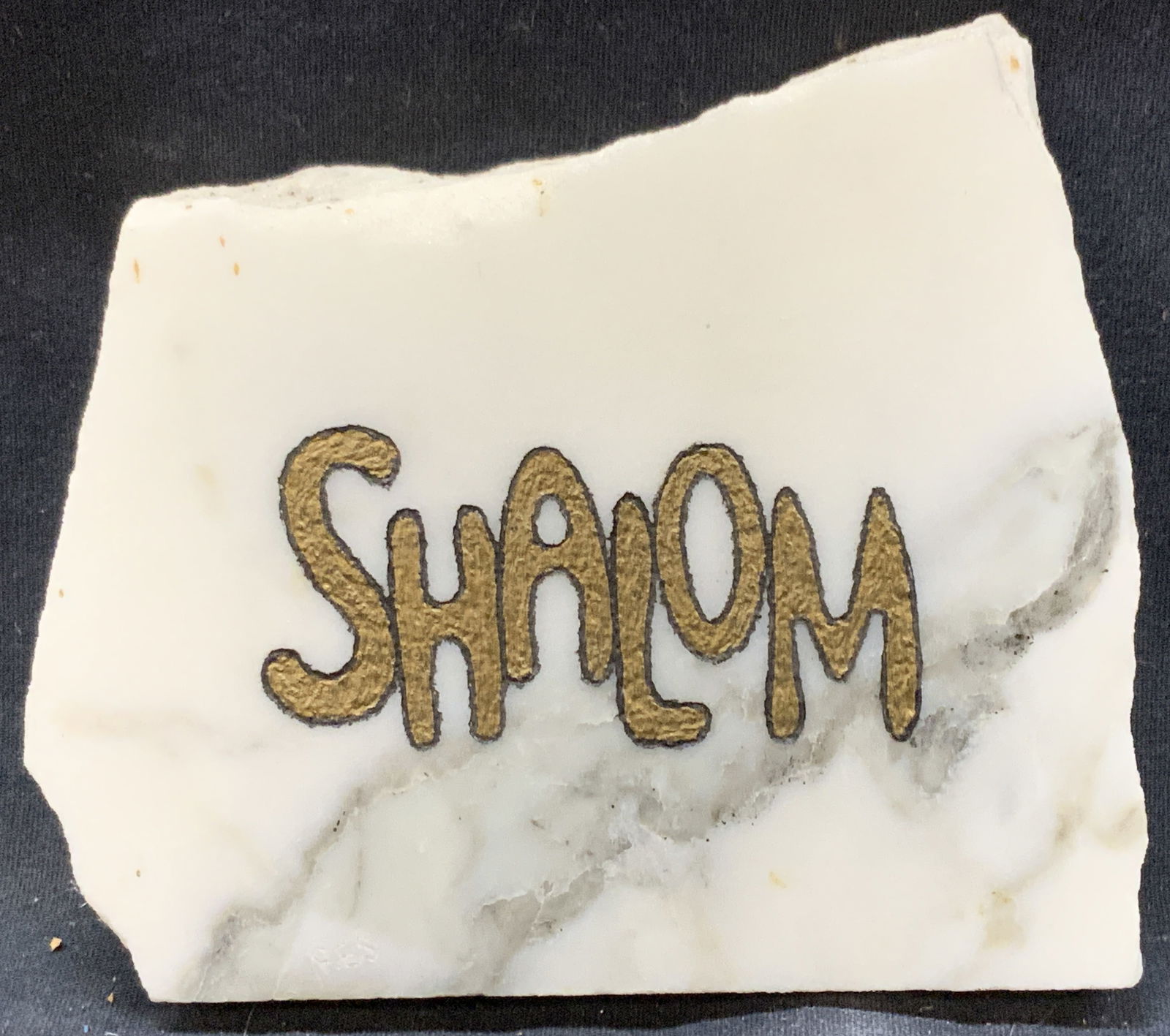 Howard Resnick Marble Engraving: Marked on backside Howard Resnick, original engraving. A white piece of marble with the engraved text Shalom and filled with gold leafing. Approx 5 x 4.25 inches Moderate wearing to marble edges and c