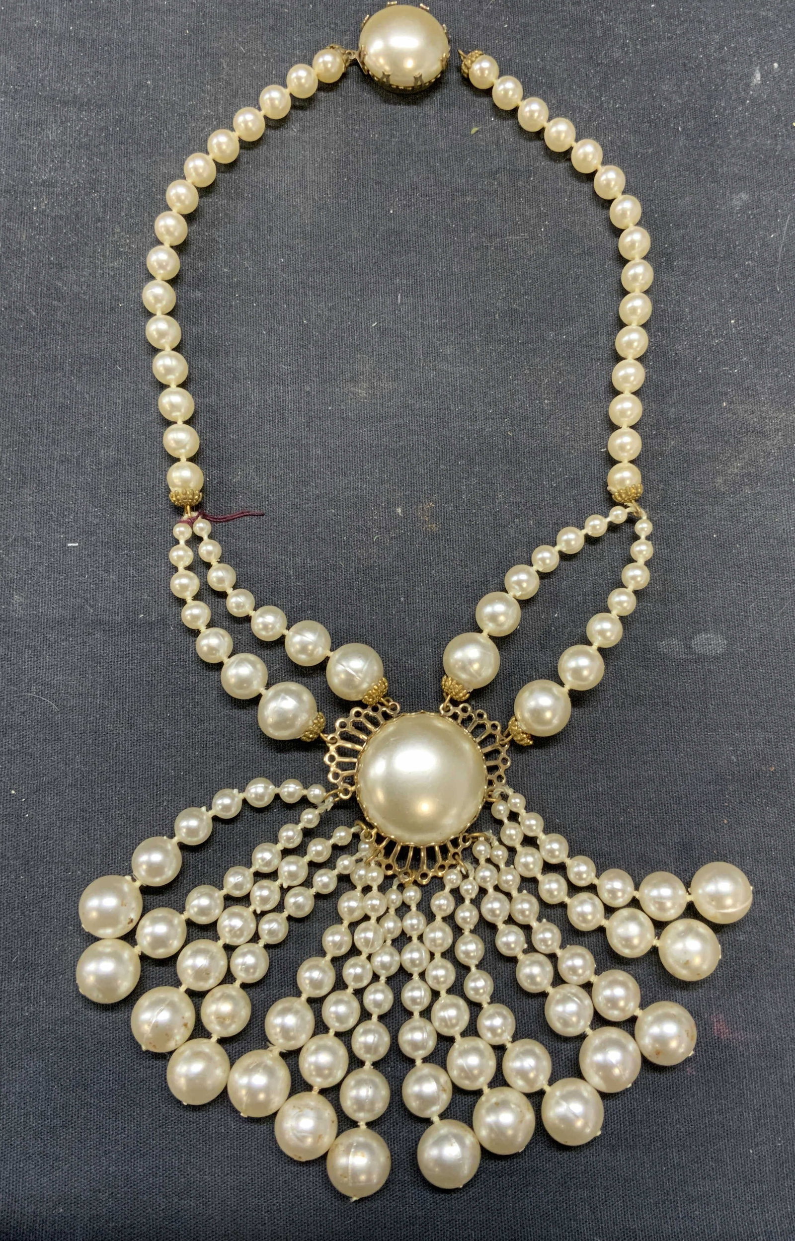 Vintage Faux Pearl Pendant Necklace: Vintage faux pearl pendant necklace. Dangling faux pearl strands. Drop length approx. 8 inches. Pendant drop approx. 3.5 inches. Some surface wear including scratching observed. Clasp needs repair. Es