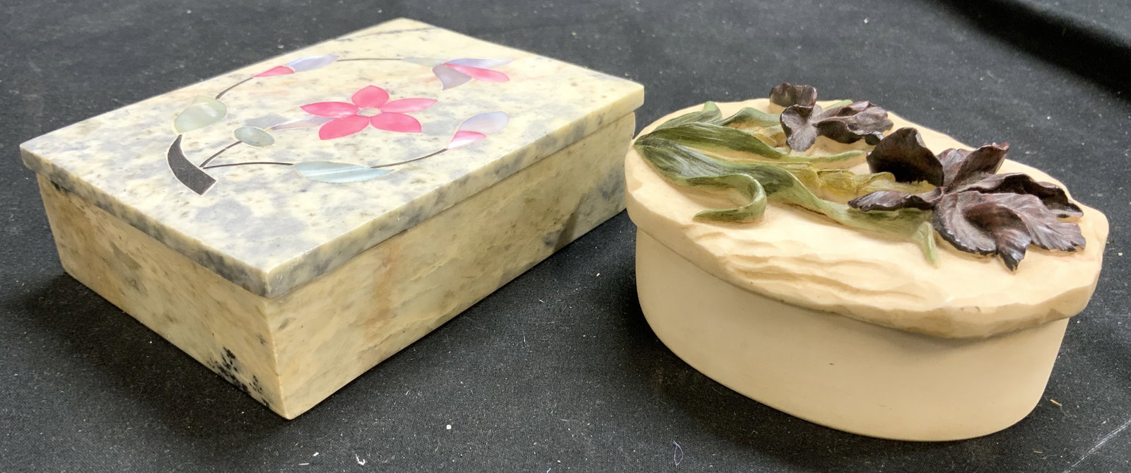 Lot 2 Stone & Resinous Trinket Boxes W Lids: Lot includes 1 stone trinket box, cream and slate toned with multi toned floral and leaf mother of Pearl detail on lid, & 1 resinous trinket box with beveled floral and leaf detail on lid. Each box in