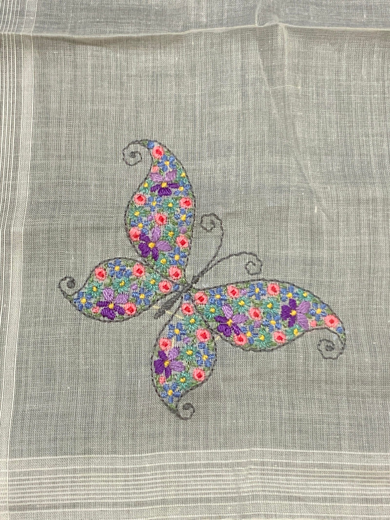 Vtg Embroidered Butterfly Handkerchief: Vintage white toned linen handkerchief with intricate embroidered butterfly on corner with flowers in blues, pink and purples within the butterfly. Approx 11 x 11 inches Moderate wearing to fabric, pu