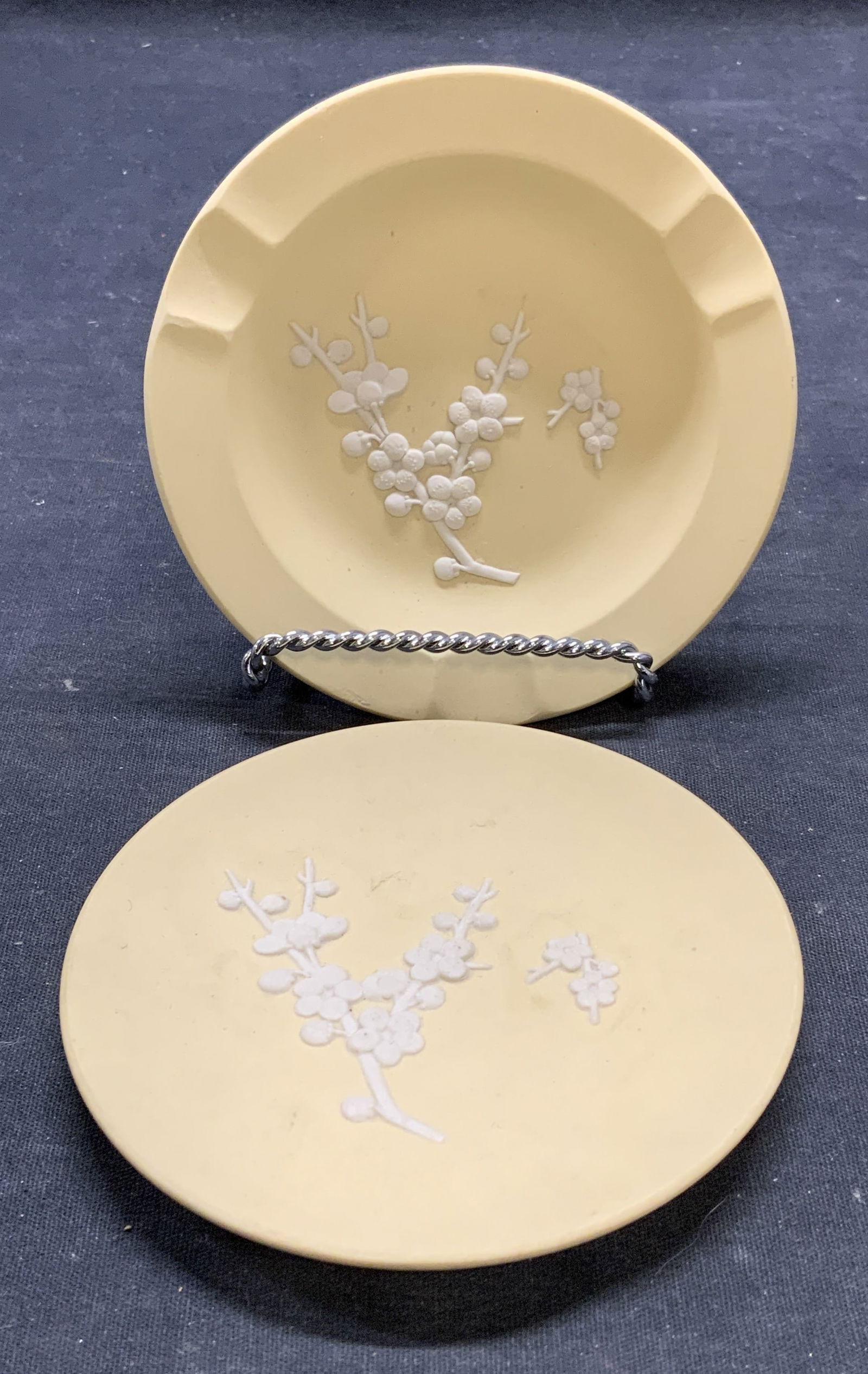 Lot 2 Vtg Wedgwood Yellow Dish & Ashtray England: Vintage Wedgwood yellow Jasperware dish and ashtray with raised white bas relief floral motif. Signed to underside. Made in England. Larger piece measures approx. 4.5 inches diameter. Both pieces have
