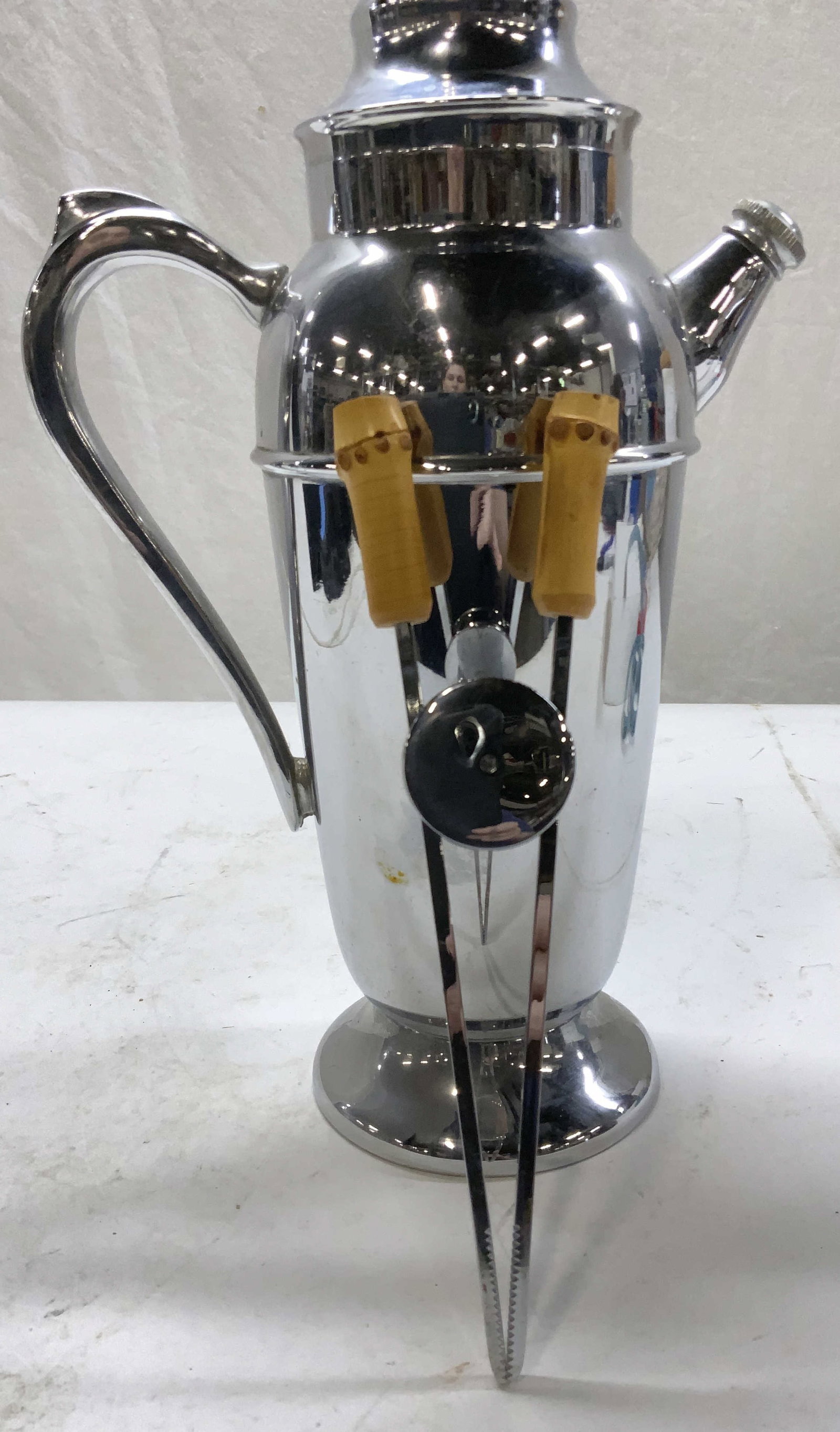 Chrome Plated Tee / Coffee Pot and Ice Prongs, 2: Mid century chrome plated tea / coffee pot server ware has a screw off spout cap. Measures 12.25 in ht. , 8 in total width. MC Bamboo handle ice prints with teeth. Chrome and bamboo. Measures 8.5 in. 