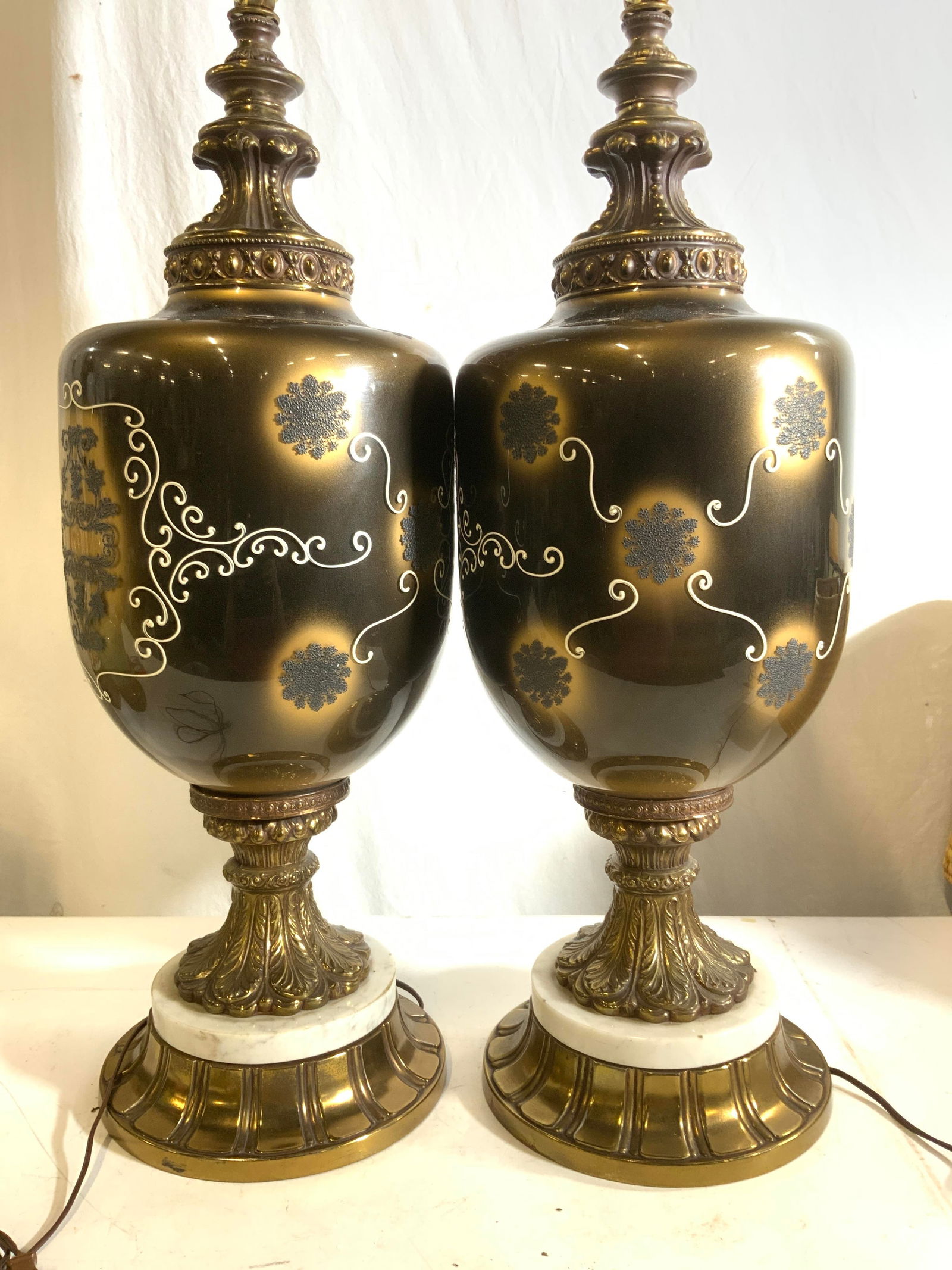 Pair Gilt Brass & Art Glass 3 - Way Lamps: Bronzed Art glass lamps with applied painted, Victorian styluses scrolling . Embellished gilt brass including bases with marble. No finials. These are 3 Way Lamps. Measure 41.25 in. Tall x 10 in wide.