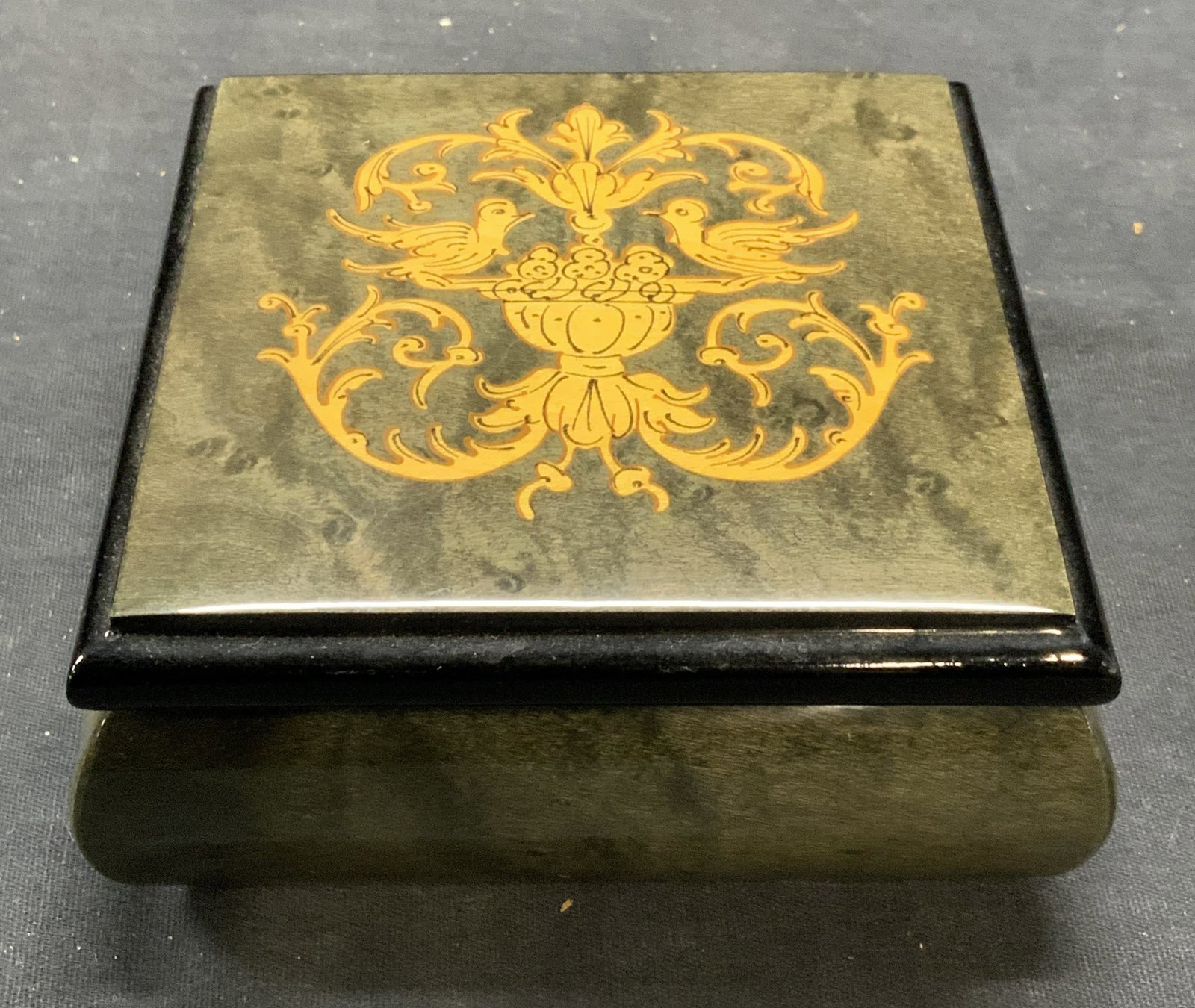 Lacquered Wood Bird Jewelry Box, Italy: Lacquered wood jewelry box in green with black border. Bird and scroll motif on lid. Made in Sorrento, Italy. Measures approx. 4.25 x 4.25 x 2 inches. Some surface wear including scratching observed. 