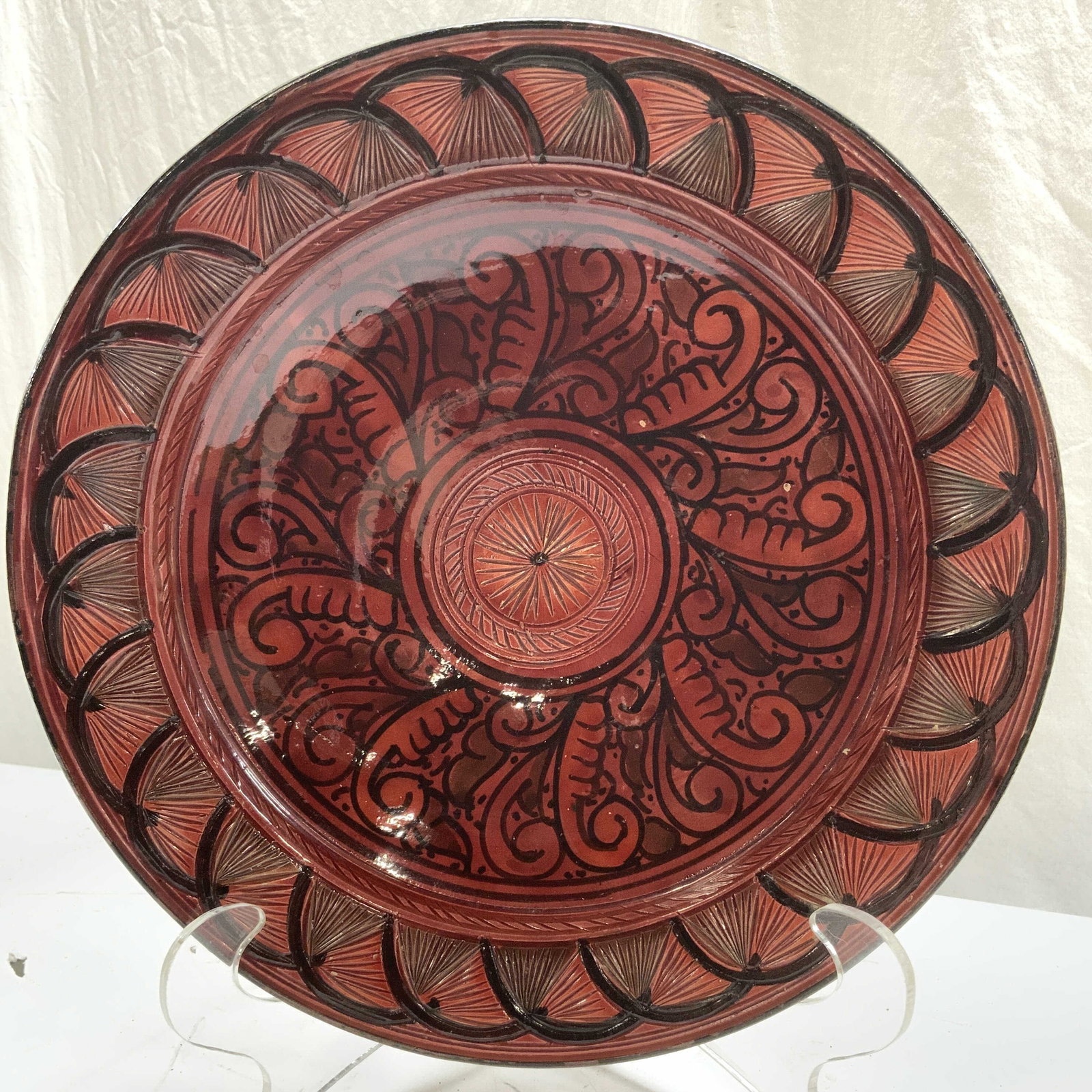 Moroccan Pottery Centerpiece Dish: Terra cotta Moroccan dish. Red and black with middle eastern / Moorish designs. There are holes on under side for hanging. Made and bought in Morocco. Measures 14.25 in. Diameter,,2.5 in ht/ depth. Mo
