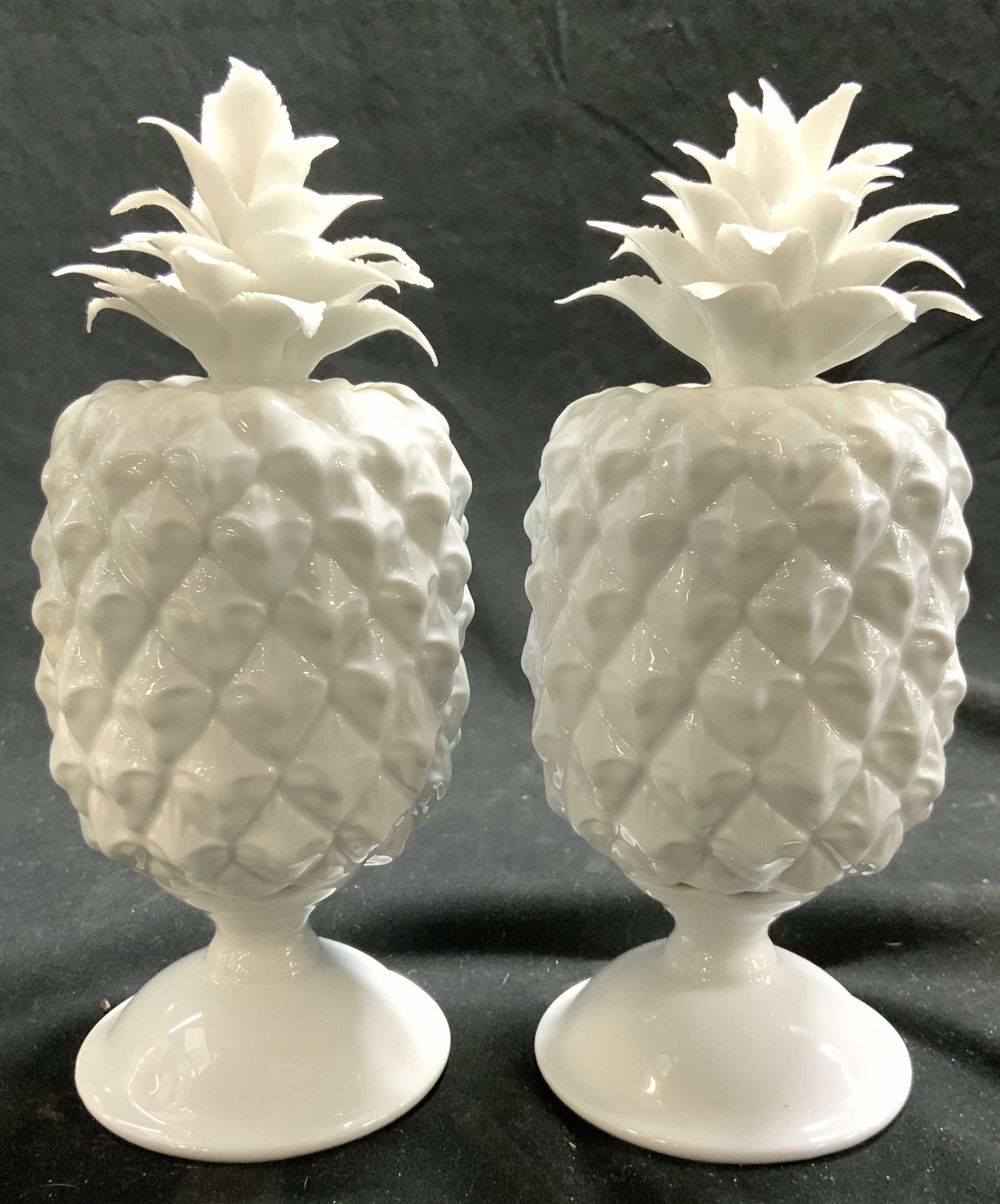 TWOS COMPANY Pr Porcelain Pineapples White: Undersides are marked TWOS COMPANY. Lot includes 2 pineapple figures, each are white toned and porcelain. Each piece is footed 7.25 inches tall 3 inches wide. Twos Company pineapples, porcelain pineap