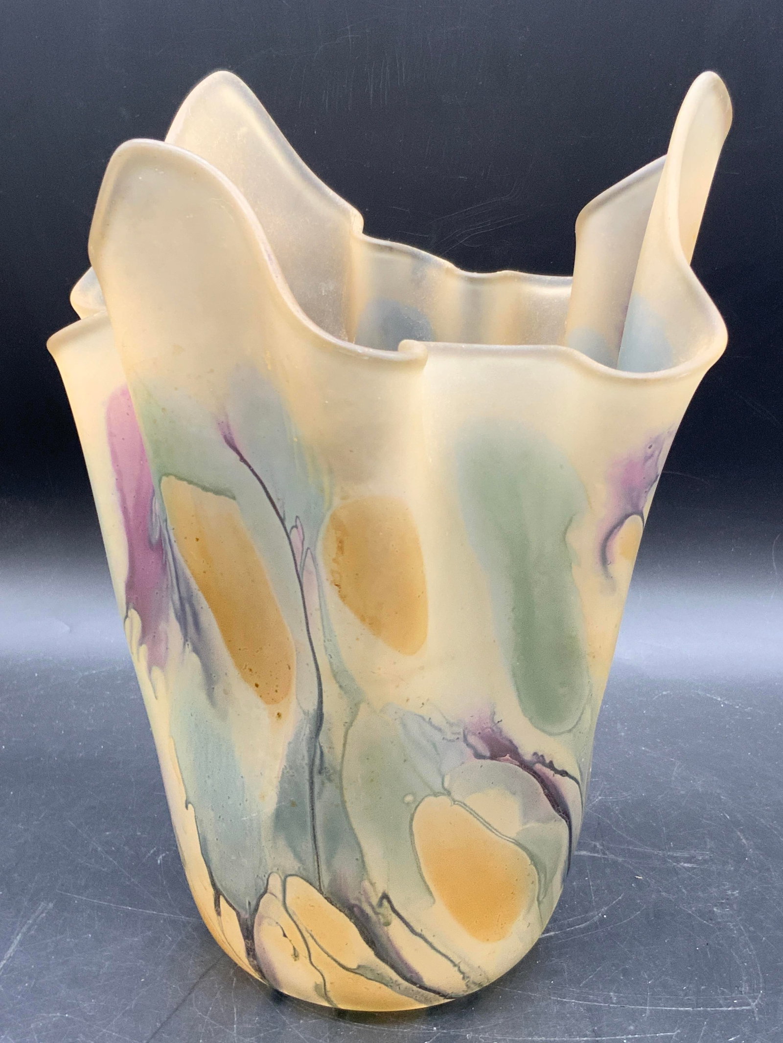 RUEVEN GLASS Hand Painted Israeli Glass Vase: A hand painted handkerchief rim Israeli glass vase. Underside sticker reads HAND PAINTED RUEVEN GLASS BY NOUVEAU ART GLASS CO. INC. USA. Measures approx. 9.5H x 7.25W in. Some surface wear consistent 