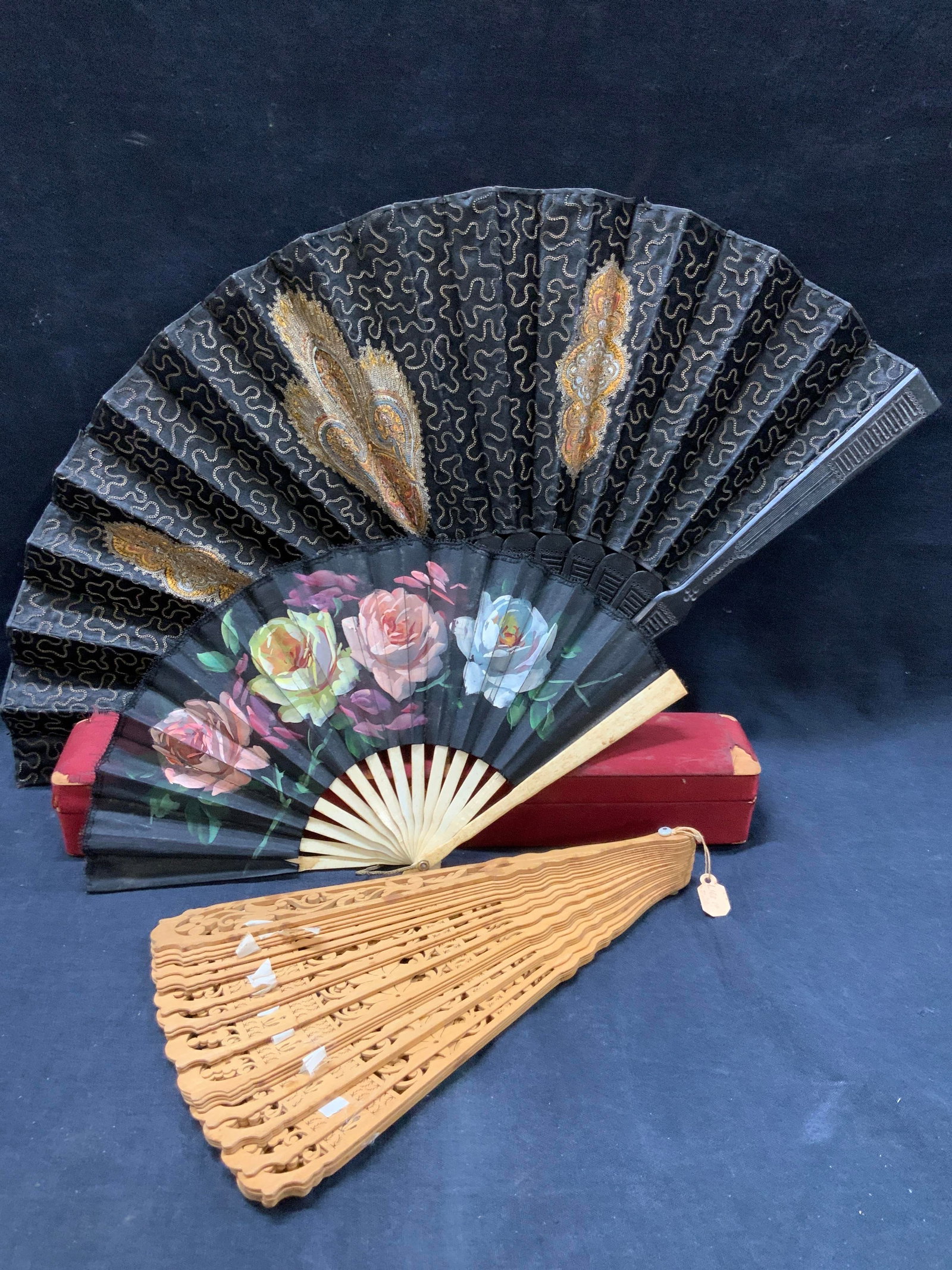 Lot 3 Hand Painted & Embroidered Hand Fans: Lot of 3 assorted hand fans. 1 carved wooden fan, 1 hand painted linen fan with carved bone frame and flowers painted on linens, and 1 fan with embroidered scroll and floral patterns at 11 inches long