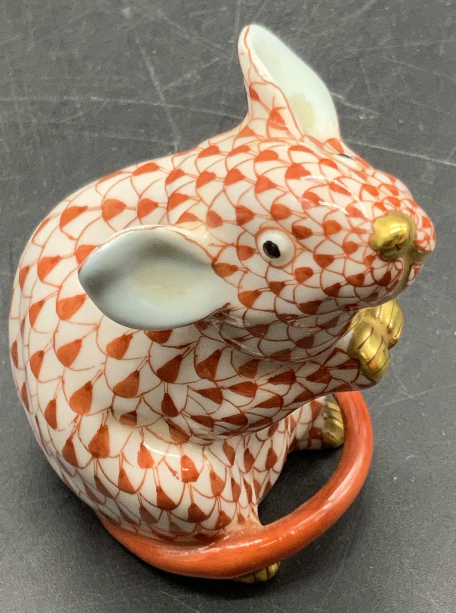 HEREND HUNGARY Porcelain Fishnet Mouse Figural: Rust hued fishnet Herend mouse figural crafted from porcelain and signed on the underside. Gilt accents to the paws and nose. Measures approx. 2.25W x 1.5W in. Drilled hole to underside. Some wear con