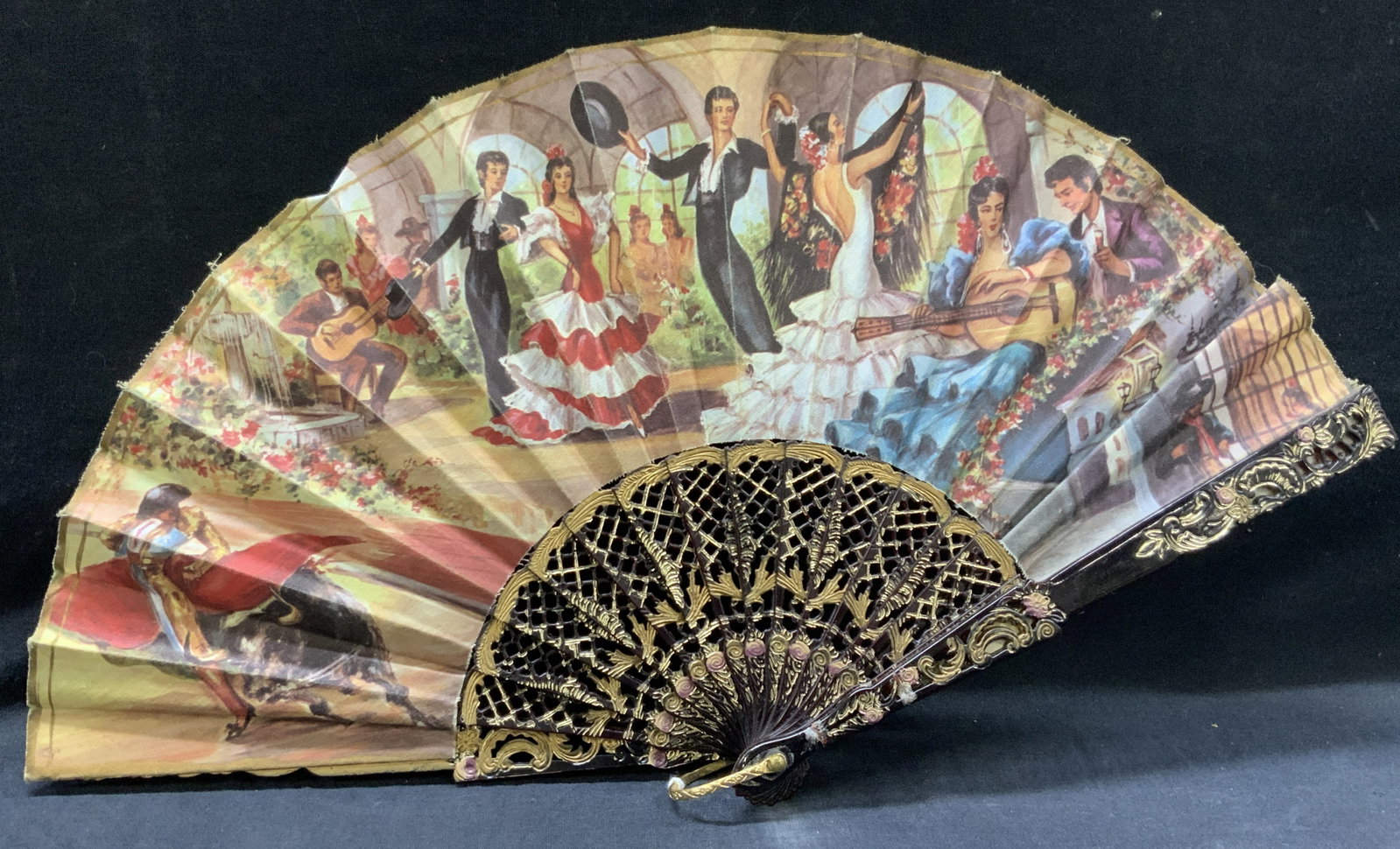 Vintage Spanish Flamenco & Bull Fighting Fan: Vintage hand fan with printed images of flamenco dancers and a bull fighter , made with a red toned hard composite material with hand applied gilt scroll accents with rose details. Approx 9 inches lon
