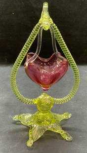 Pink Art Glass Basket & Uranium Glass Stand: Hand blown pink Art glass basket with yellow uranium Art glass stand. Cable motif and pulled detail on stand. Stand fluoresces under UV light. Handkerchief rim on basket. Stand measures approx. 