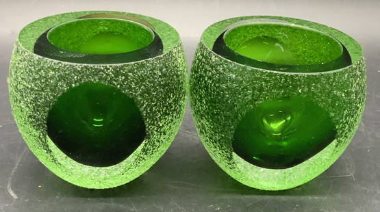 Pair Green Textured Art Glass Candle Holders: A pair of green art glass candle holders featuring textured glass and polished glass. Measures approx. 3.5H x 3.75W in. Some wear consistent with age, use, and exposure. Sticker residue present.