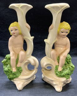 Pair Vintage Ceramic Putti Figural Candle Holders: Pair of vintage ceramic putti cherub figural motif candle holders. Hand painted in white, green, and yellow. Measure approx. 4.5 x 3 x 11 inches. Both pieces have some surface wear including