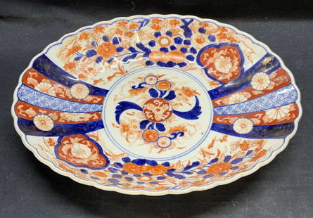 Vintage Asian Imari Porcelain Platter, 13.25 In: Vintage, possibly antique Asian imari porcelain platter. Oval shape with scalloped rim. Hand painted with gilt detail in hues of red and blue with floral motif. Measures approx. 13.25 x 10 x 2.5