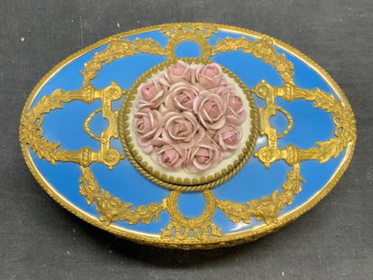 Vintage Gilt Porcelain Floral Dresser Box: Vintage porcelain dresser bow in blue with raised floral motif. Gilt metal frame with scroll motif. Measures approx. 6.5 x 4.5 x 3.5 inches. Some surface wear including scratching and small chips