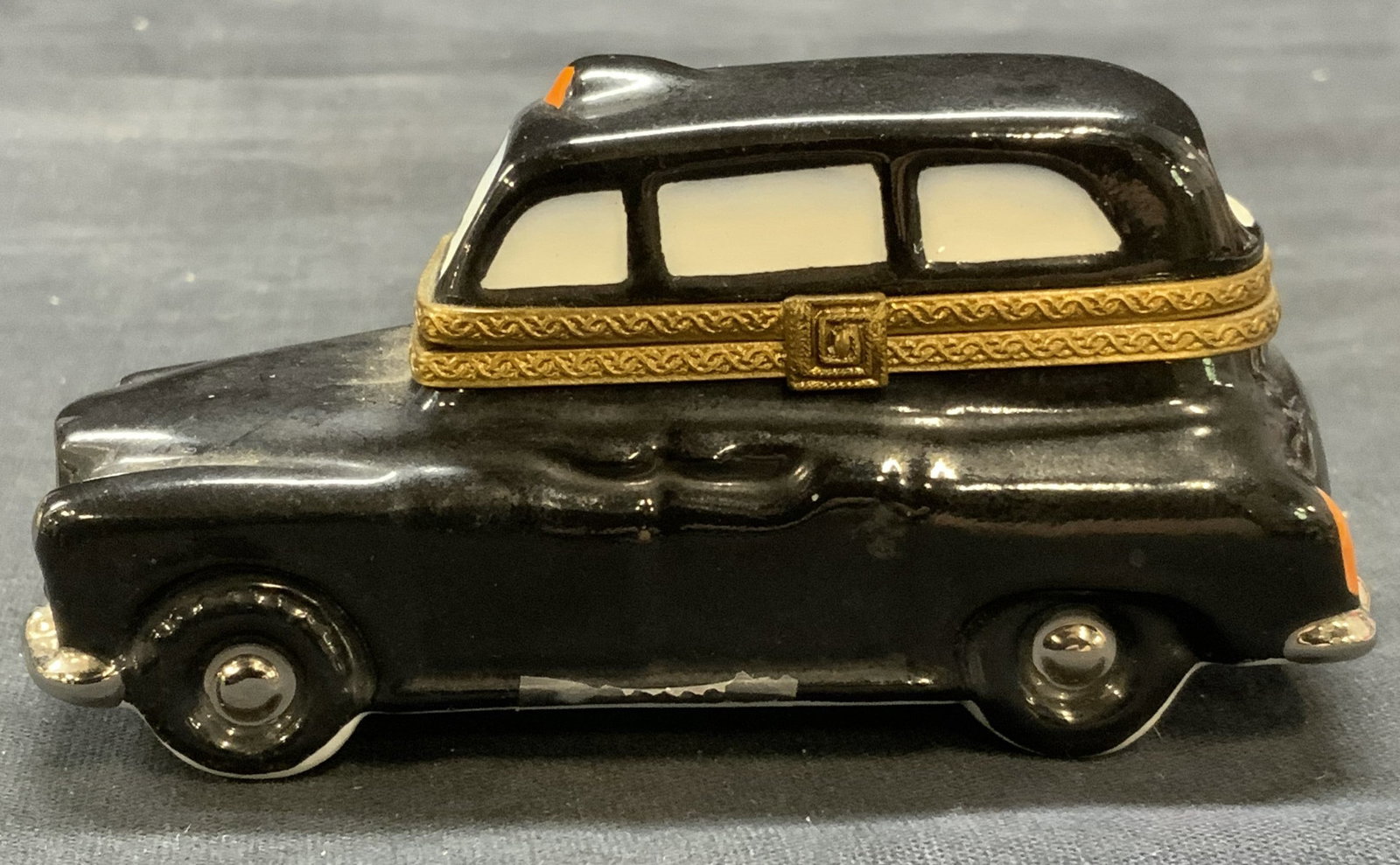 Vintage Limoges Porcelain Taxi Trinket Box, France: Vintage Limoges porcelain taxi motif trinket box. Hand painted in black and white. Raised brass frame and latch. Trademarked to underside. Made in France. Measures approx. 3.75 x 1.5 x 1.75 inches. So