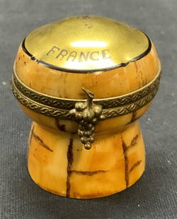 Limoges Porcelain Champagne Cork Pill Box FRANCE: Vintage Limoges porcelain champagne cork motif trinket box with raised brass grape motif frame and latch. Hand painted with gilt decoration. Signed to underside. Made in France. Measures approx.