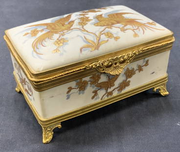 Limoges Gilt Porcelain & Brass Jewelry Box, France: Stamped on underside with Limoges, France. White toned porcelain jewelry box with brass made frame and footing with ornate filigree style braided to latch. Adorn on the lid is a pair of birds in