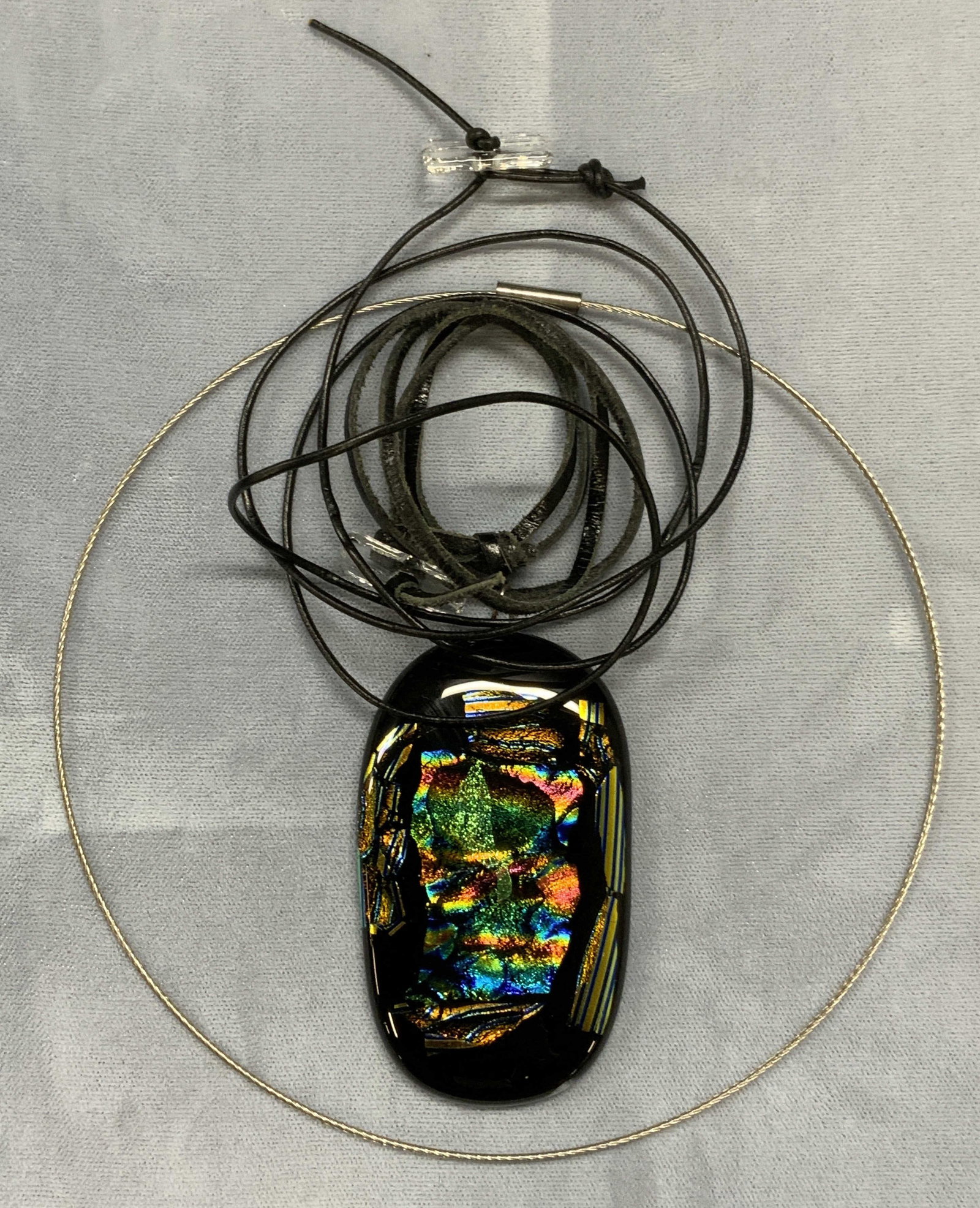 Lot 3 Handcrafted Art Glass Necklace +: Handcrafted art glass pendant necklace on black cord. Iridescent multi color pendant. Drop length approx. 9.25 inches. Pendant measures approx. 2.75 x 1.5 inches. Also includes additional black cord n