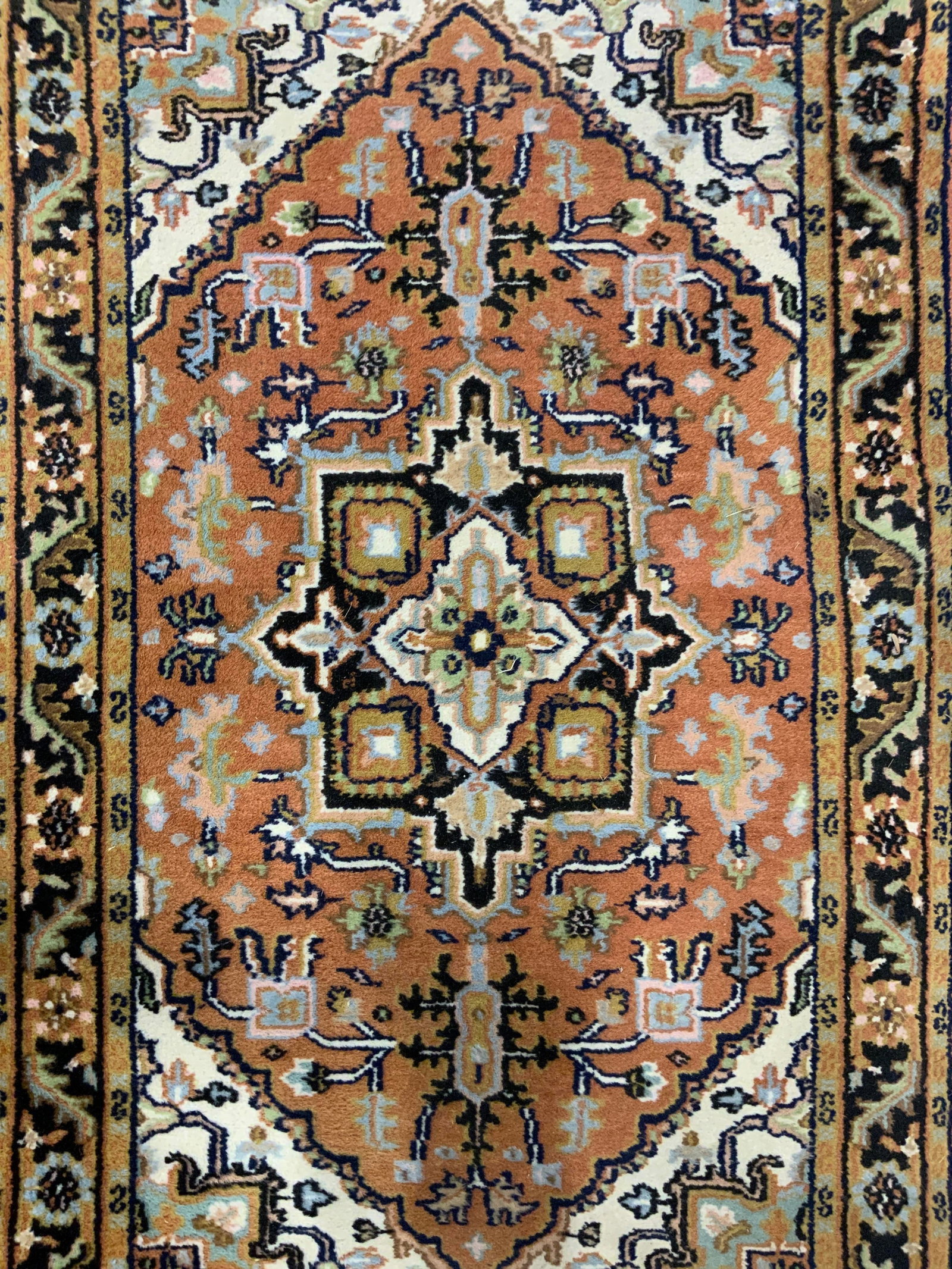 Vintage Handmade Oriental Wool Rug: Rug is handmade and wool. Piece is vintage. Rug is oriental. Piece has multi toned floral, leaf and geometric detail. Cream toned fringes at edges. Rug measures approximately 61 inches long 36 inches 