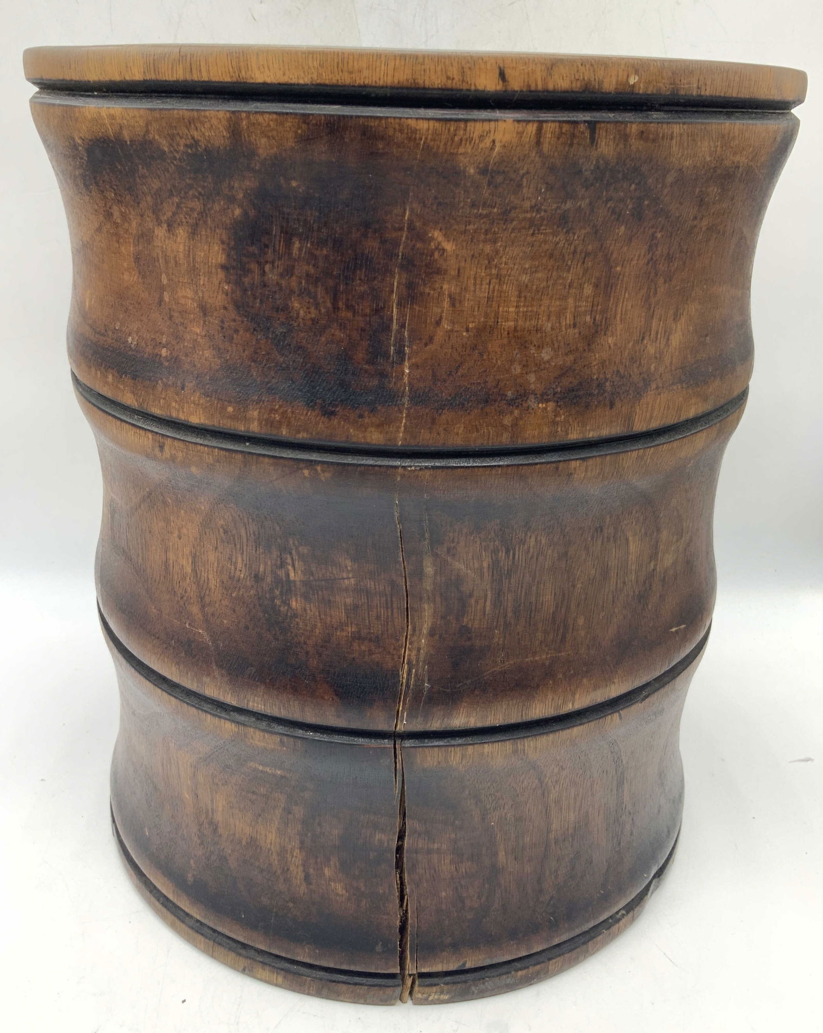 Treenware Solid Wood Hand Turned Bin: Hand turned solid wooden treenware bin, in a dark brown tone with notches on surface. Approx 12.5 inches tall and 11 inch diameter. Moderate wearing to surface and some cracking to exterior. Treenware