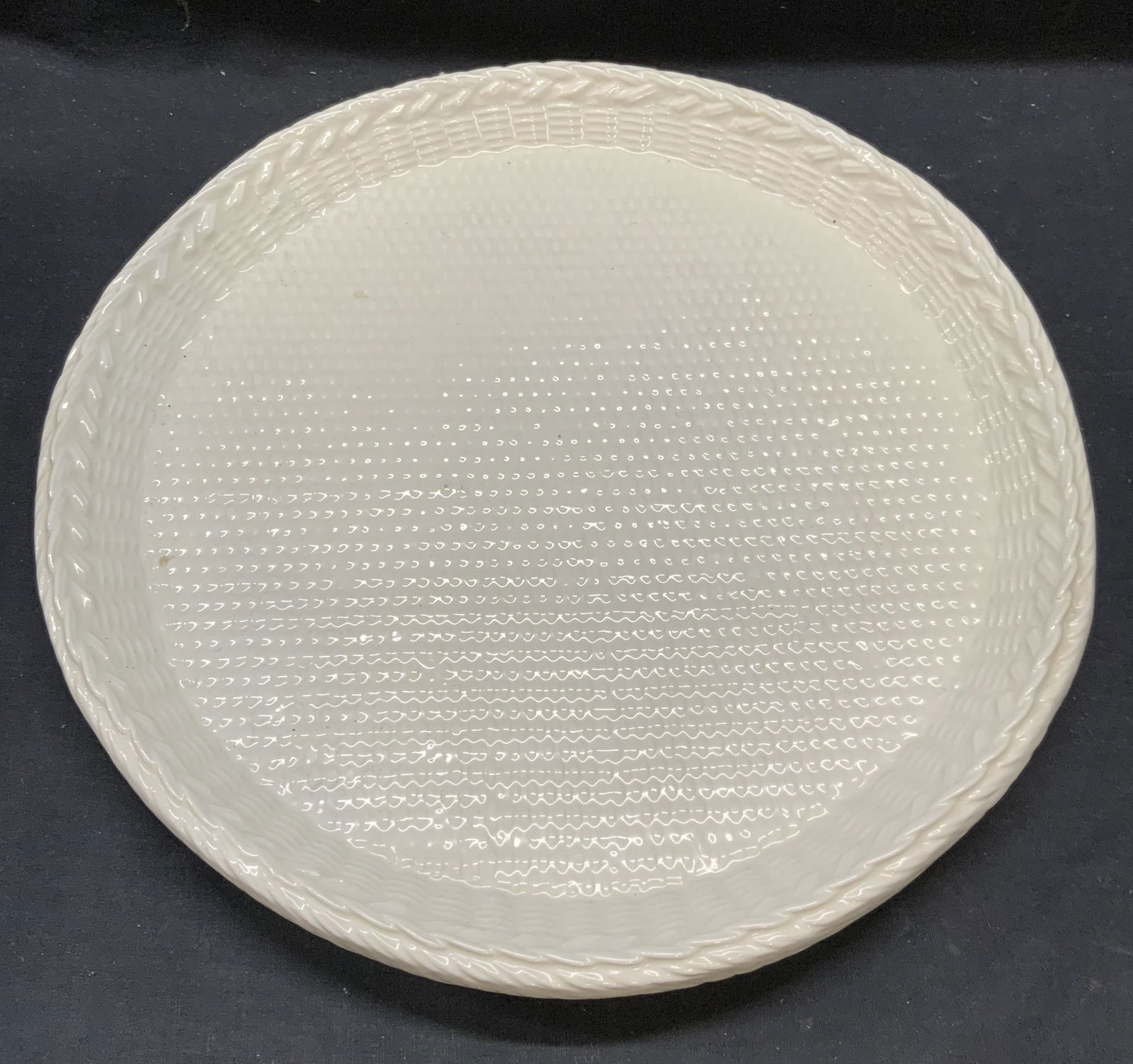 Vtg Tiffany Ceramic Basket Weave Platter, Italy: Vintage Made in Italy for Tiffany and Co white ceramic round platter with raised basket weave motif. Signed to underside. Measures approx. 14.5 x 2 inches. Some surface wear including scratching obser