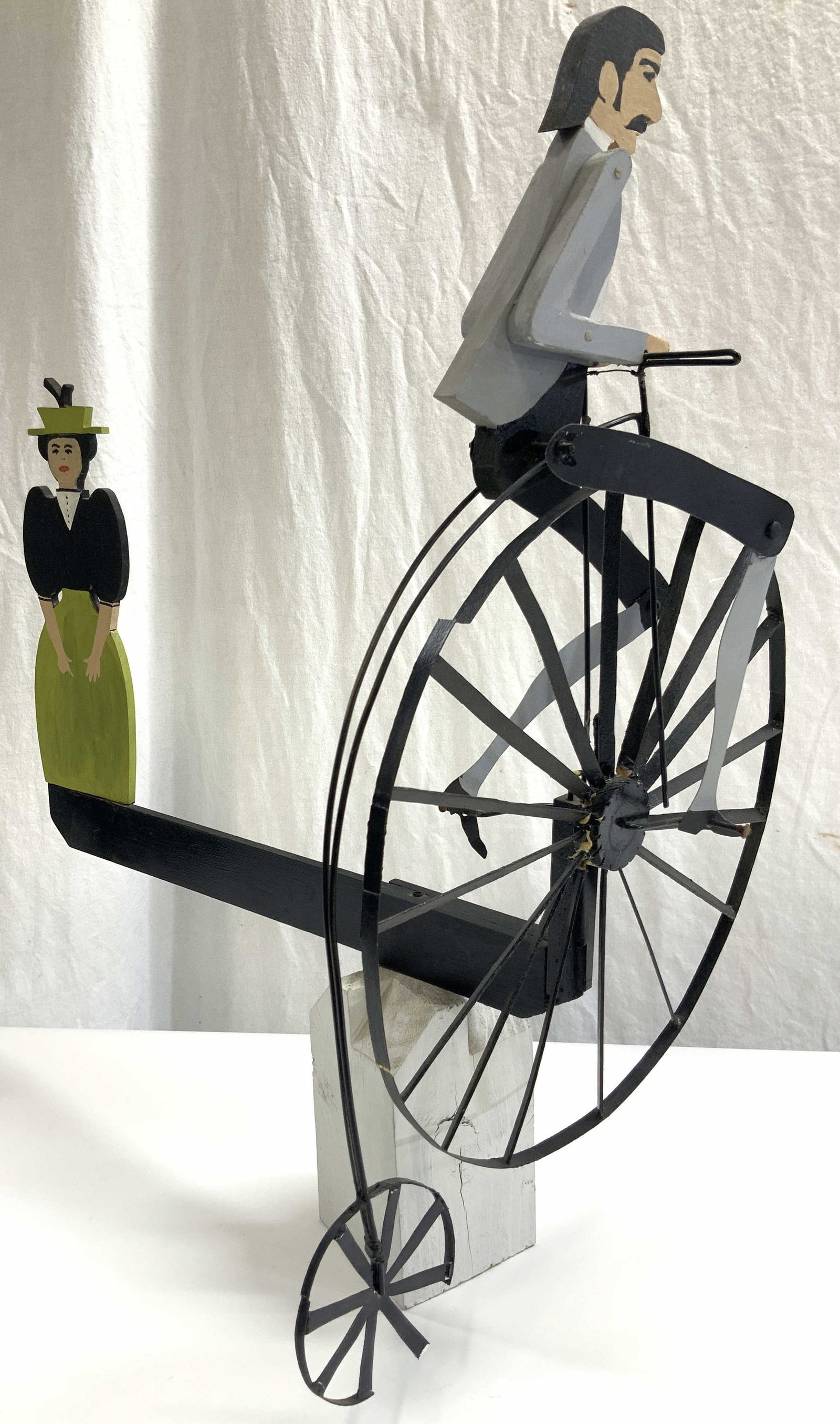 Vtg H.Cross Crafted Wooden Whirligig: Sgd H.Cross, Vintage wooden carved and hand painted whirligig of a man on a penny farthing with a woman on the other end, feet on pedal motions and spins, piece spins with pedal Motion Approx 23 inche