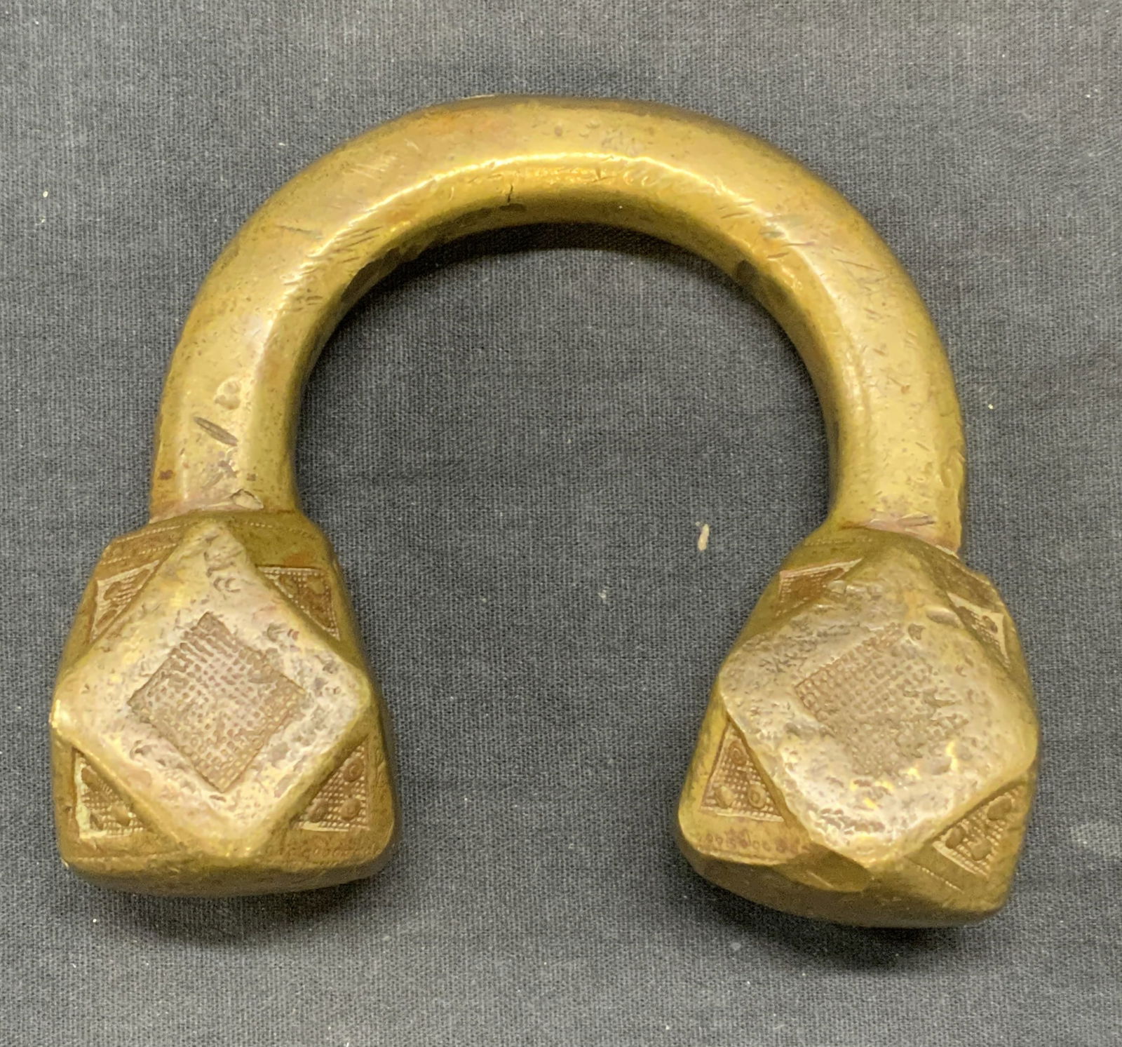 Antique African Bronze Tuareg Anklet: Antique African bronze Tuareg anklet. Handmade geometric tip with stamped detail. Solid bronze. Piece is heavy. Measures approx. 4.5 x 1.5 x 4.25 inches. Some surface wear including scratching observe