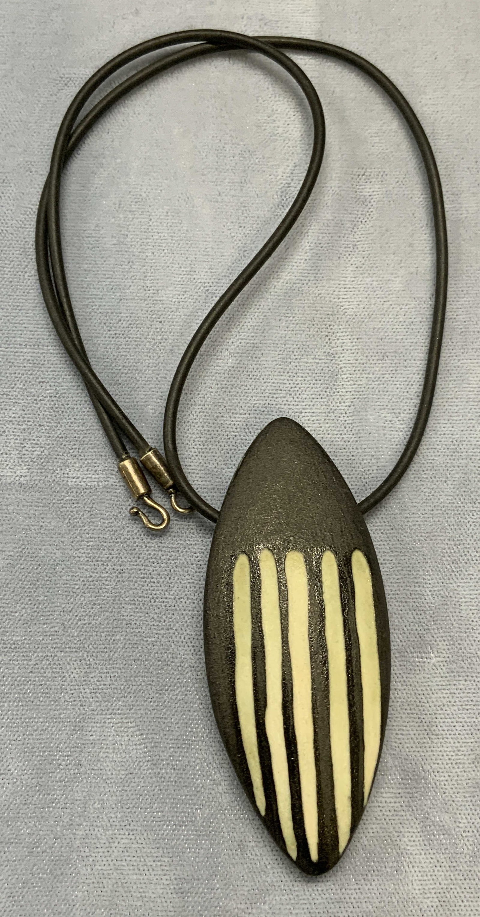 Black & White Pendant Necklace: Black and white carved pendant necklace with black cord. Drop length approx. 8.25 inches. Pendant Measures approx. 2.75 x 1 inches. Some surface wear including scratching observed. Estate jewelry, cos